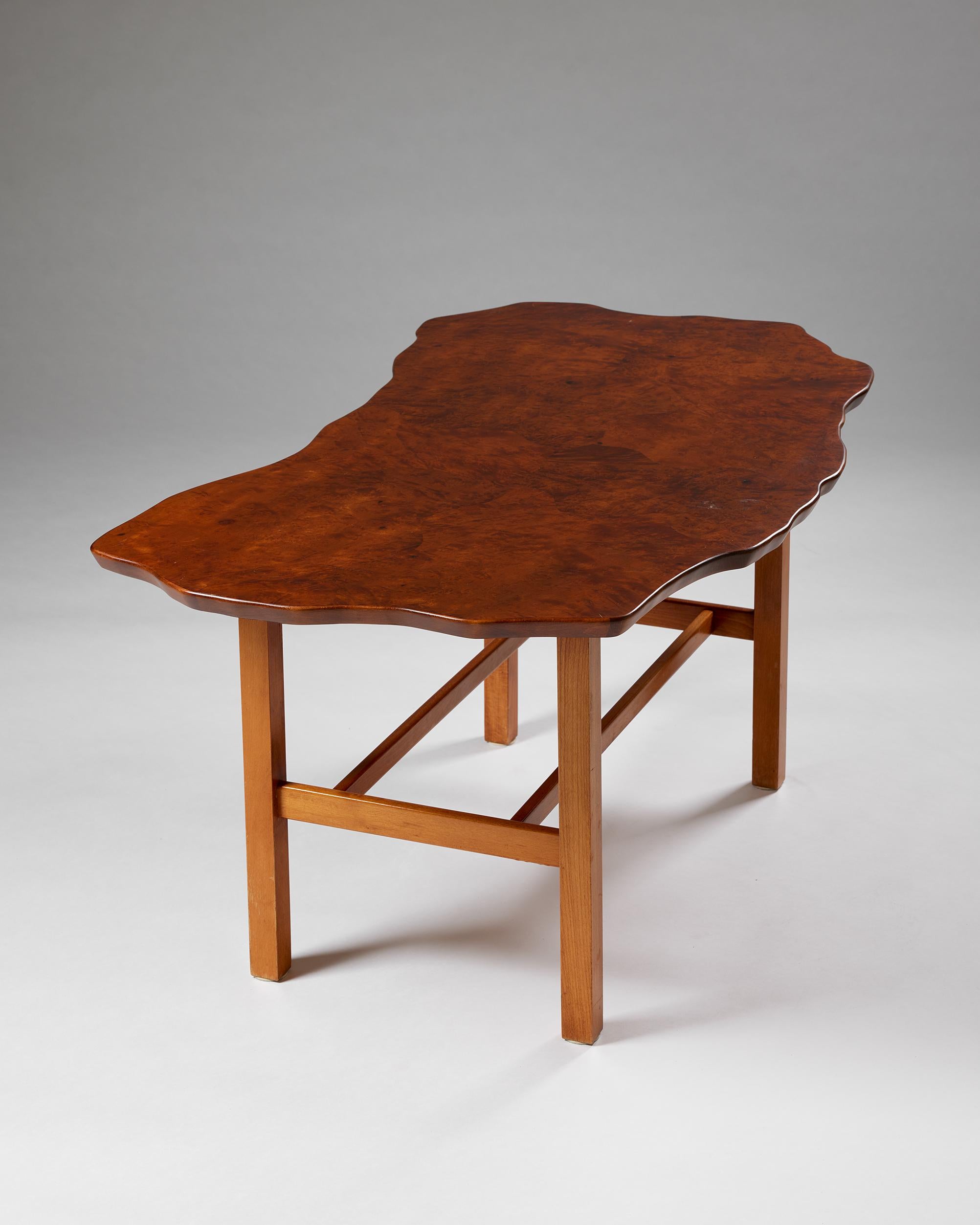 Tisch, anonym
Schweden, 1950er Jahre

Sockel aus Mahagoni und Platte aus Nussbaumwurzelholz.

H: 56 cm / 22''
W: 120 cm / 3' 11 1/4''
T: 62 cm / 2' 1/4''