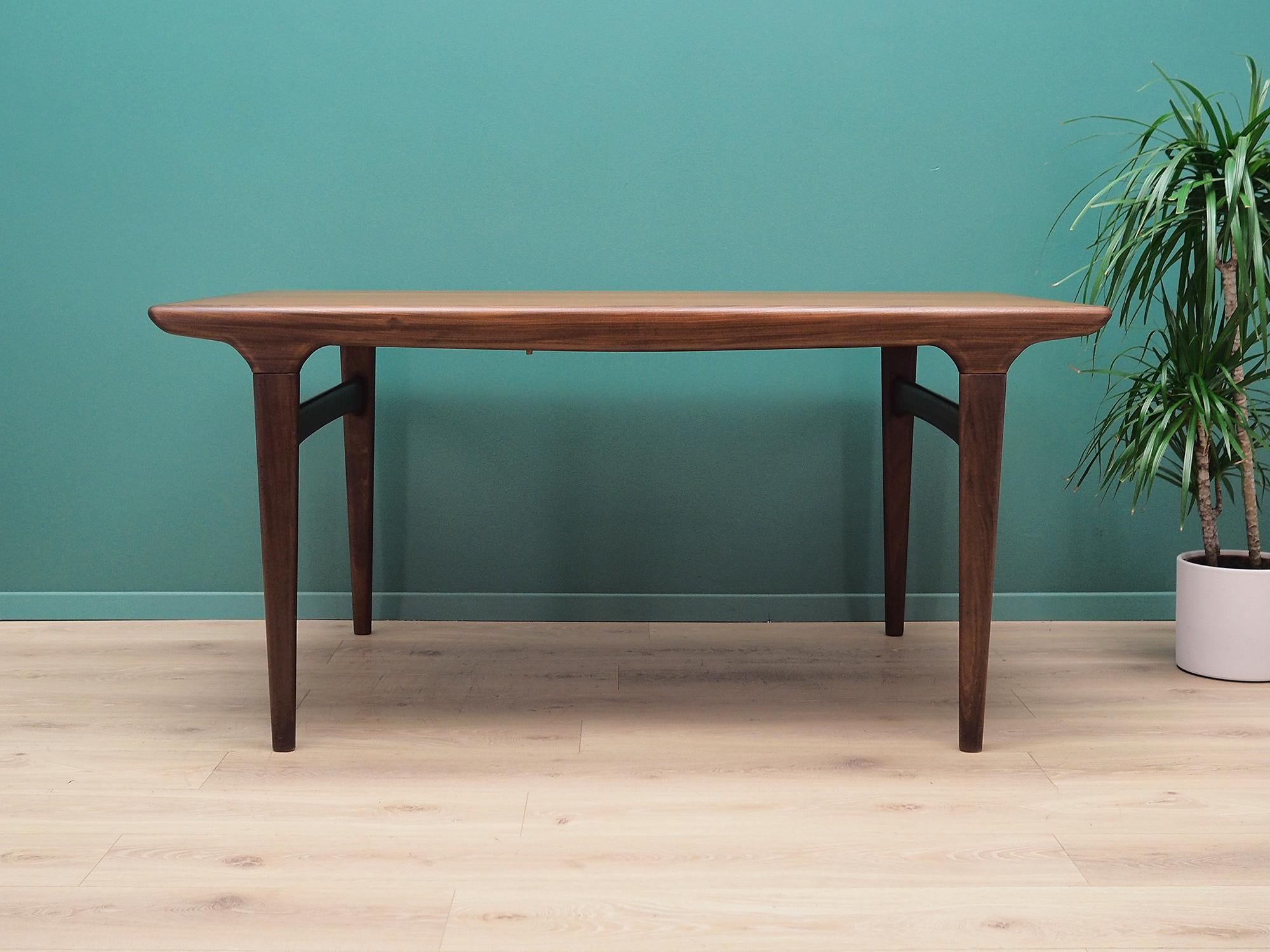 Table made in the 1970s. It was produced by the famous Danish factory Uldum. Designed by the Danish design icon Johannes Andersen.

The structure and table top are covered with teak veneer. The legs are made of solid teak wood, perfectly
