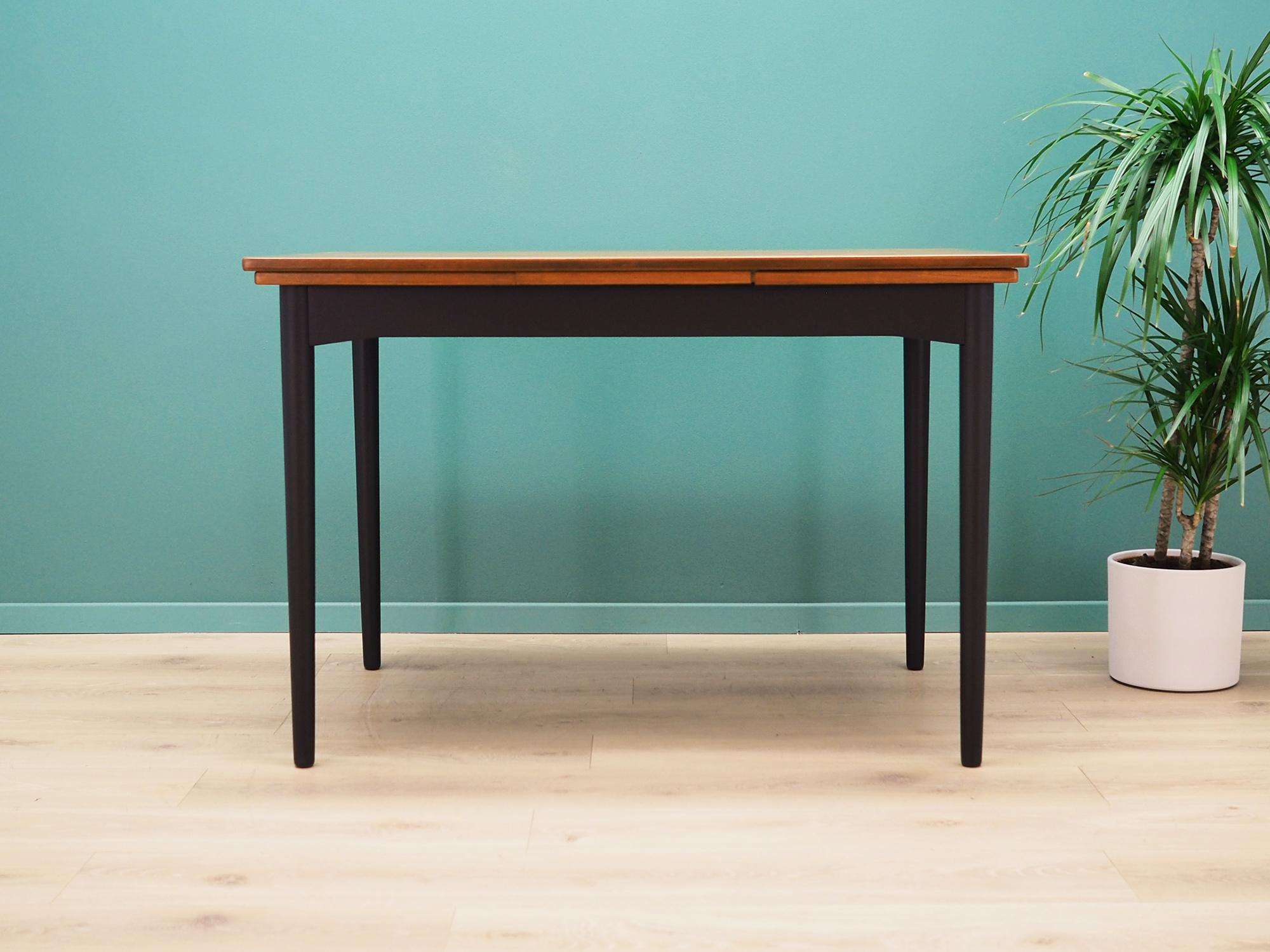 Table made in the 1970s, Danish production.

The construction and top are covered with teak veneer. The legs are made of solid teak wood. Surface after refreshing. The table has an option of unfolding the top and the possibility of extending two