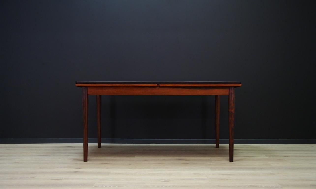 Stylish table from the 1960s-1970s, beautiful minimalist form - Danish design. Table top veneered with teak, solid teak wood legs. It has two inserts under the top. Preserved in good condition (visible small dings and scratches), directly for