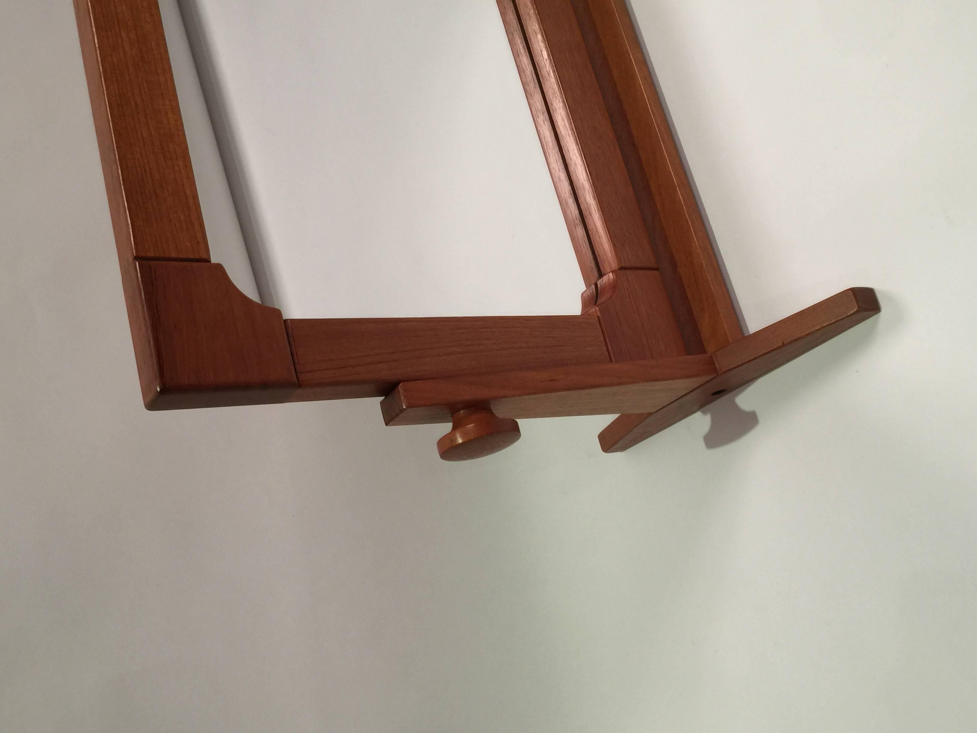 Danish teak adjustable angle mirror made by Pedersen & Hansen features detailed frame and turned round wooden knobs.
 