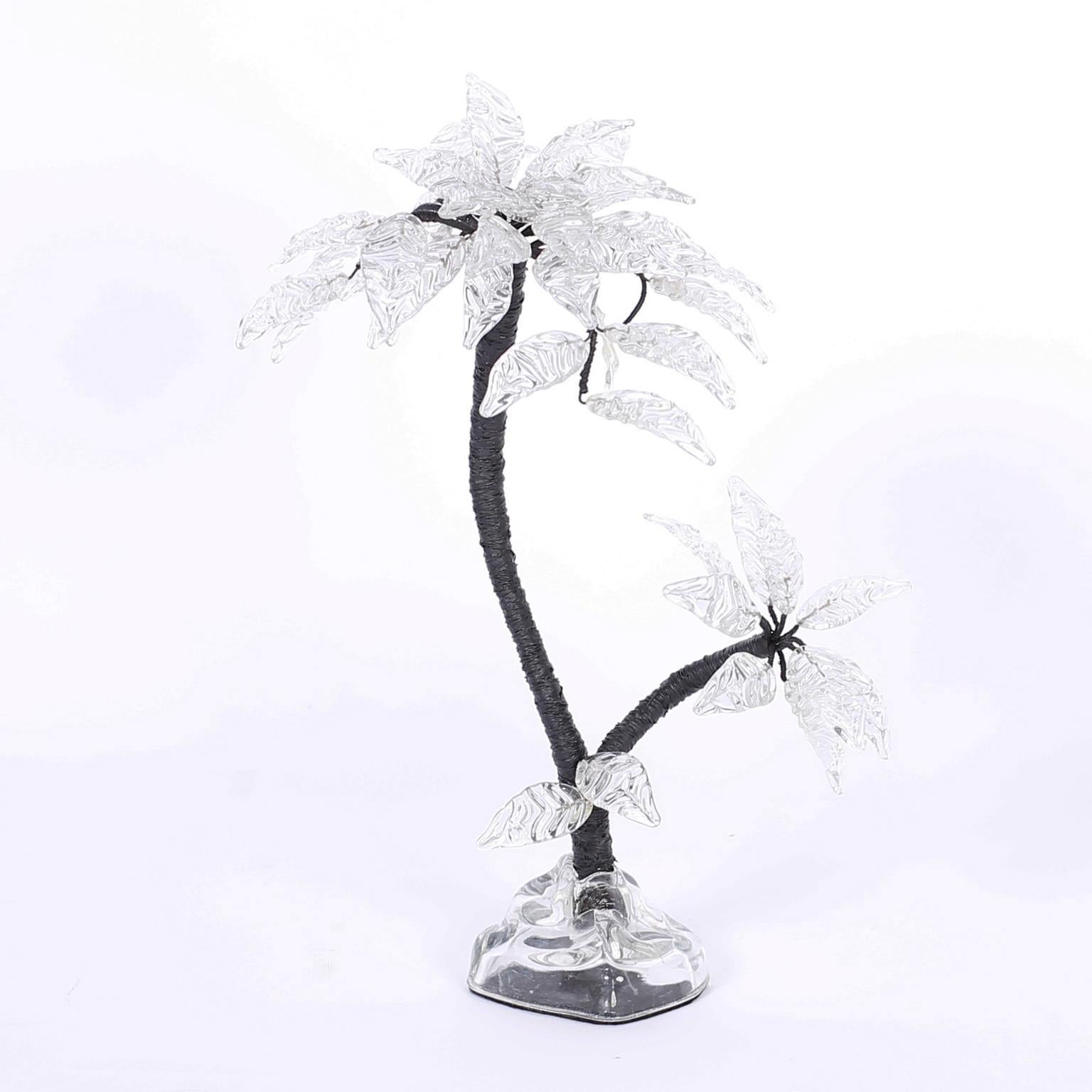 Escultura de palmera hecha a mano con hojas de cristal, tronco de metal envuelto y base de cristal de forma orgánica, todo ello con un estilizado aire moderno.