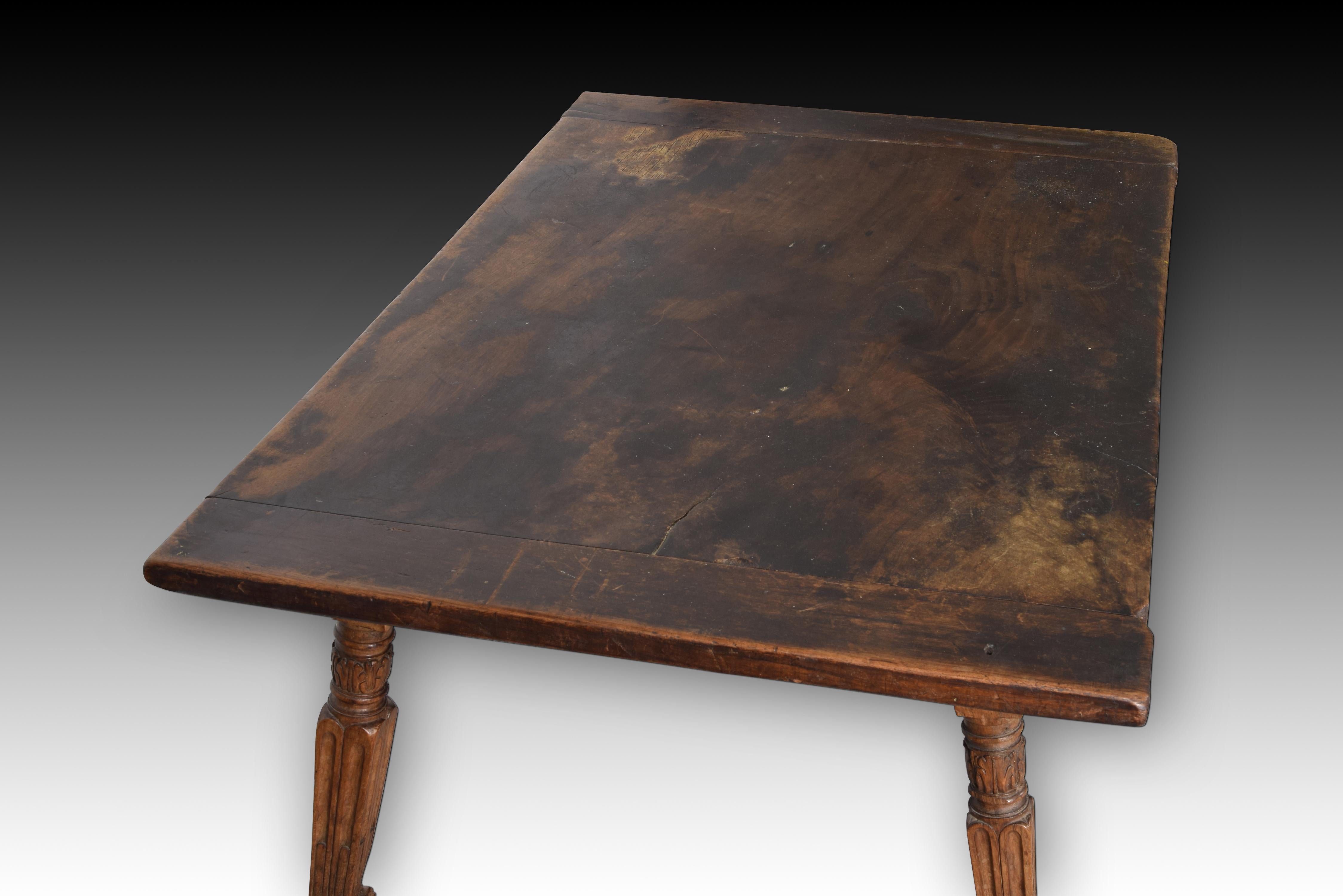 Table with grooved leg. Walnut, iron. Spain, 16th century. 
Requires restoration.
 Carved walnut table with a rectangular top and carved legs reminiscent of architectural elements with a strong classicist influence that are each joined by a wooden