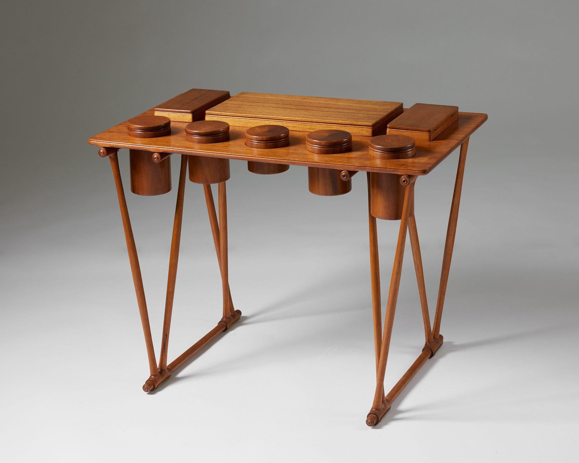 Table with compartments designed by Brockmann Petersen for Louis G Thiersen, 
Denmark, 1950s.

Mahogany, nutwood and brass.

H: 59.5 cm / 23 1/2''
H including the compartments: 62.5 cm / 2' 1/2''
W: 80 cm / 2' 7 1/2''
D: 47.5 cm / 18