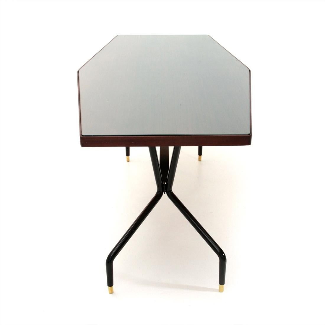 Italian manufacturing table produced in the 1950s.
Top in teak veneered wood and glass, teak edge.
Black painted metal structure, with brass feet.
Good general conditions, some signs due to normal use over time, veneer raised in some