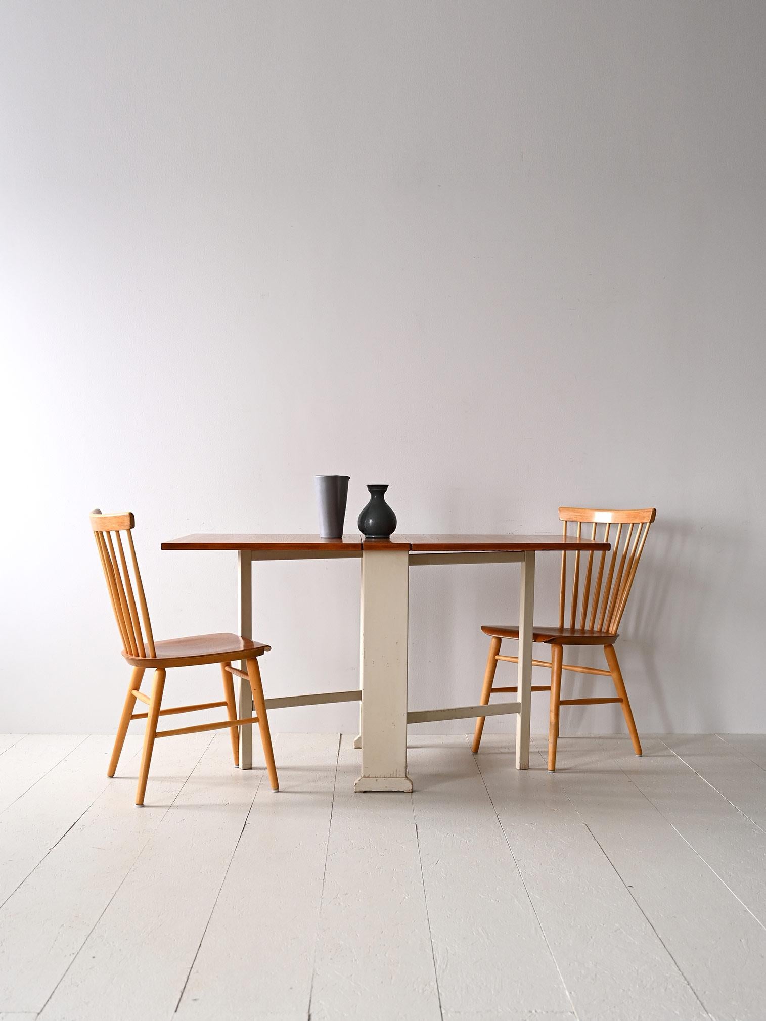 Table pliante vintage originale.

Un meuble emblématique que l'on trouve encore dans de nombreux foyers en Scandinavie. Simple et fonctionnel, il peut s'ouvrir d'un ou des deux côtés pour mesurer 165 cm de long.
Le plateau rectangulaire est en teck