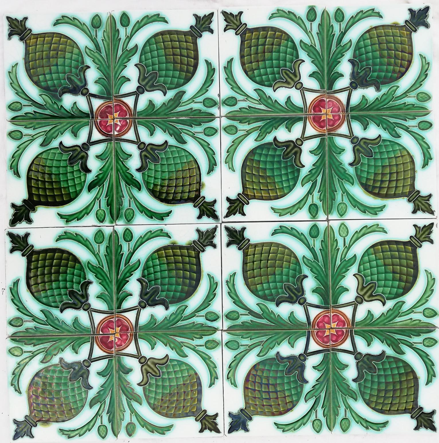 Tableau of 16 handmade antique tiles  in rich green and pink glazed colors. Manufactured around 1900 in Belgium. One tile set is divided in four squares, each symmetrically designed with a floral design. These tiles would be charming displayed on