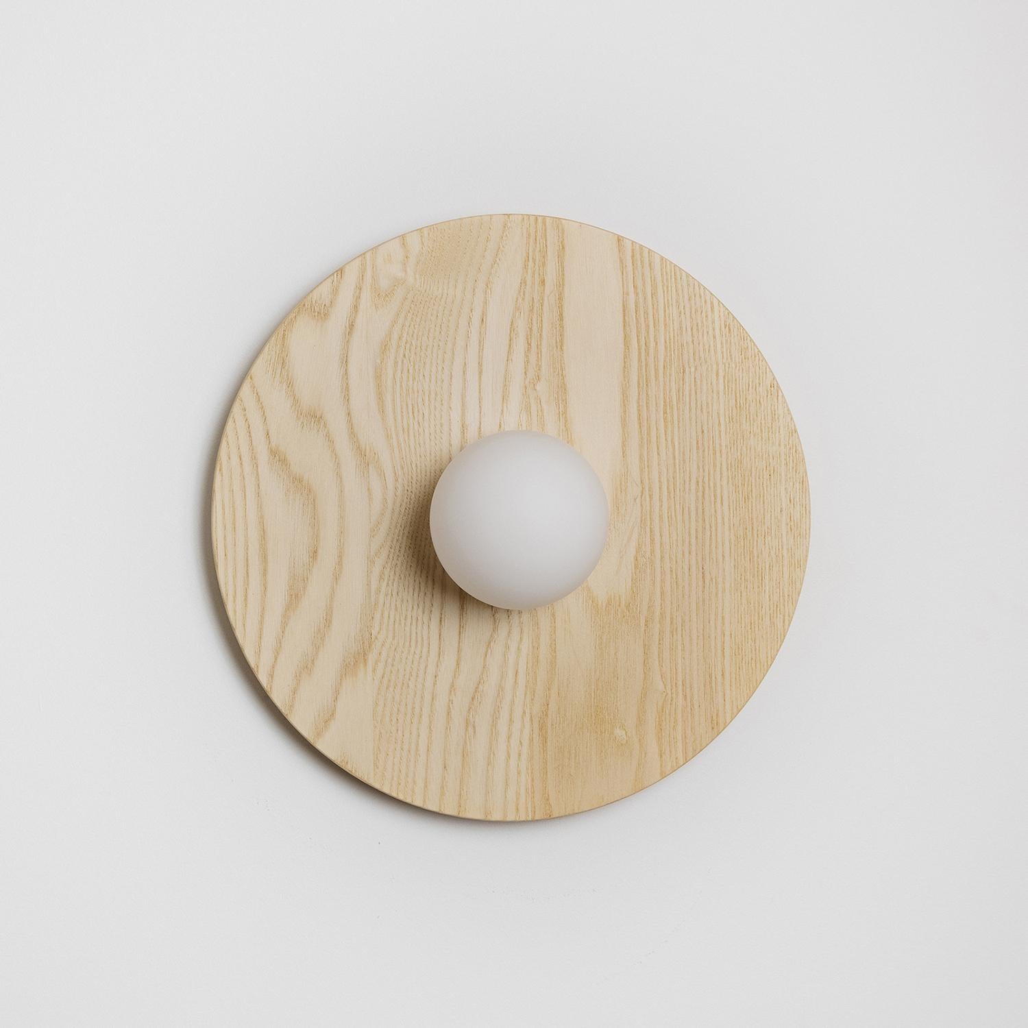 The Tablet series consists of multiple wood backing plates that showcase the glass globe as it sinks into the wood behind it. This series is available in various finishes.

This fixture can be used as a wall mount or flush mount.

Our light