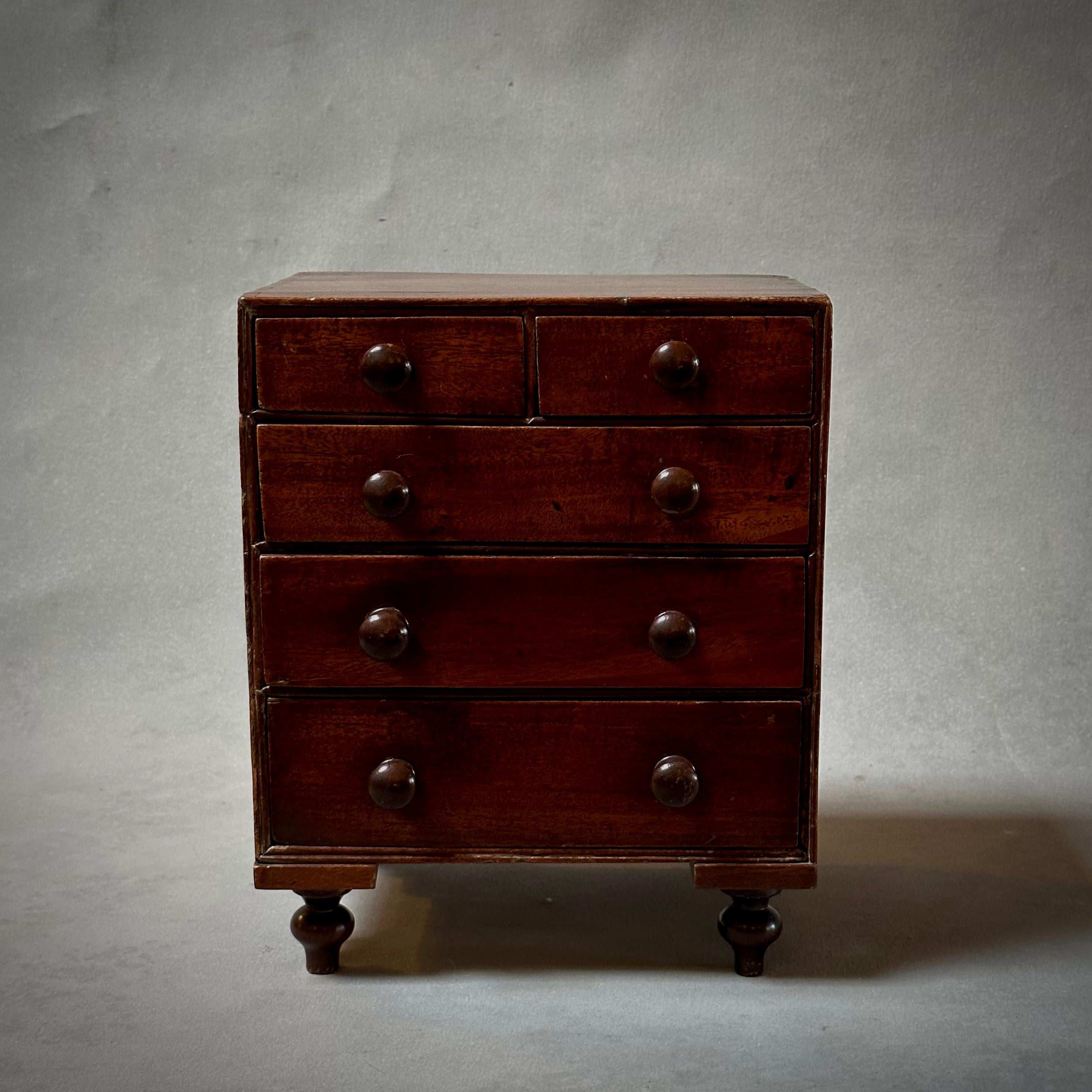 1860s English mahogany tabletop chest of drawers. Perfect for organizing jewelry or desktop materials, this unique box or storage vessel adds a touch of traditional charm to any space. 

England, circa 1860

Dimensions: 9 W x 8 D x 11 H.