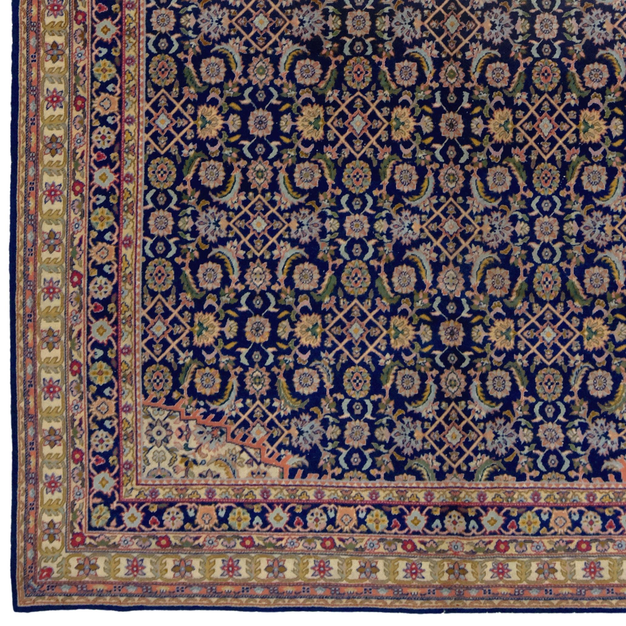 This magnificent Tabriz carpet is a rare, hand-woven treasure from the early 20th century. Woven with an elegant harmony of traditional Persian motifs, it exhibits a perfect blend of elegance and grandeur.

The intricate geometric patterns on a dark