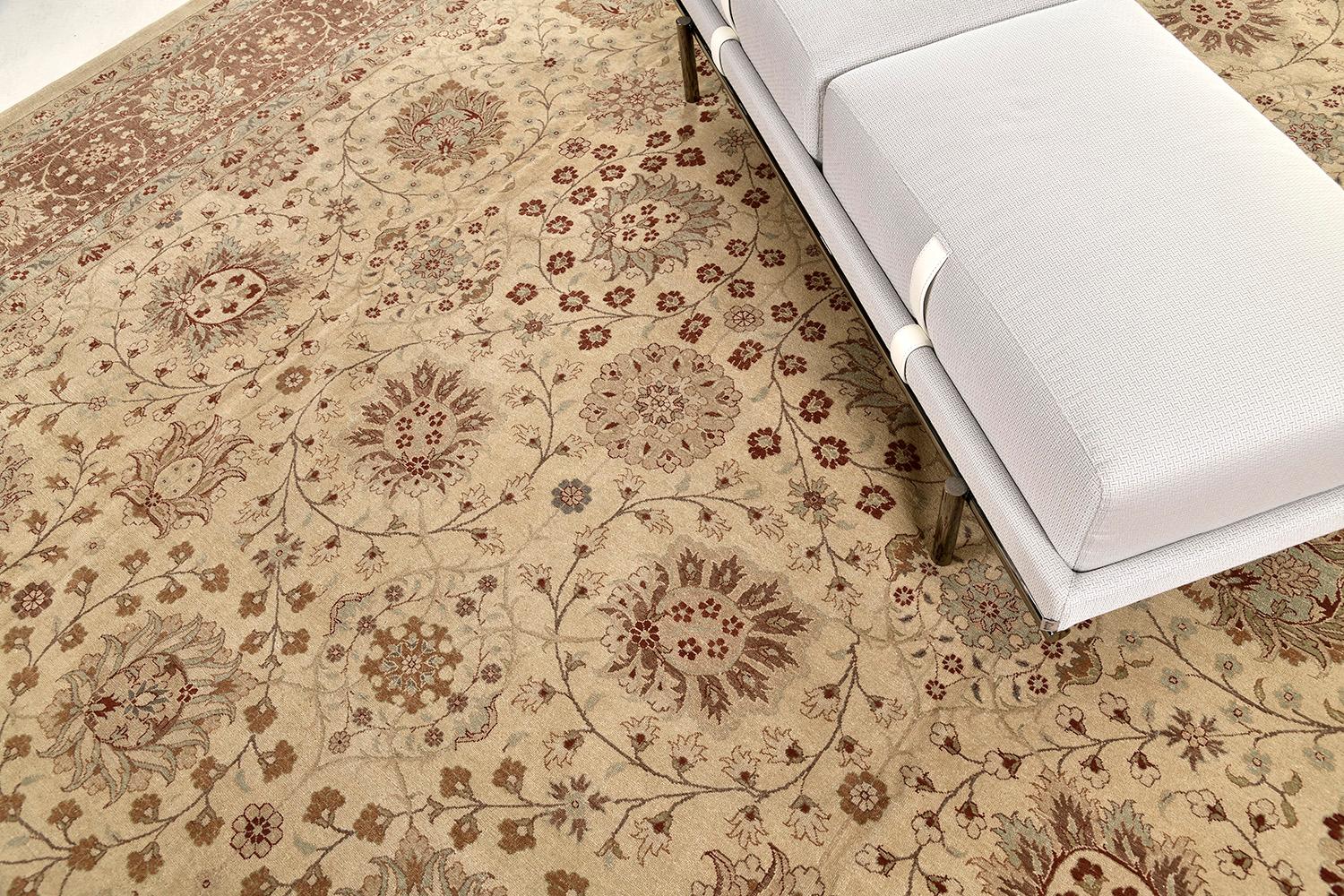 An impressive Tabriz Hadji Jalili revival rug that is rendered in earthy variegated shades of sand, tan and dusty blue. The all-over majestic botanical patterns of blooming palmettes, leafy tendrils, curved sickle leaves and stylized florals creates