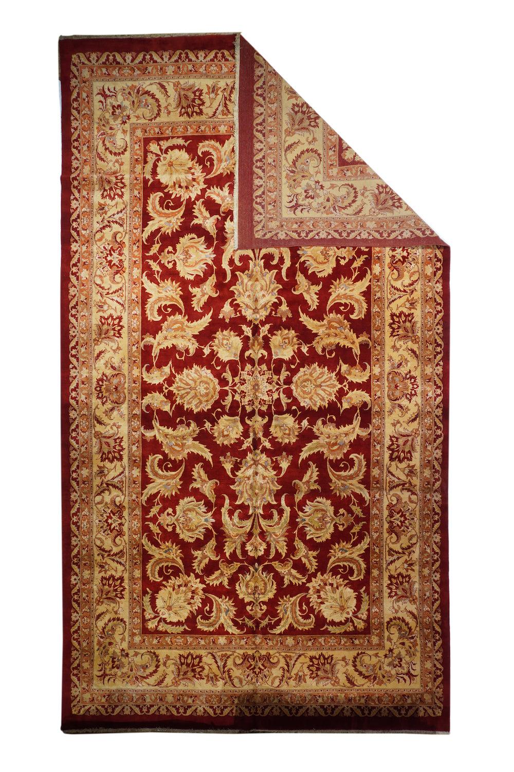 Tappeto Tabriz 9'9'' x 17'6''. Il campo rosso molto scuro mostra un medaglione centrale a rosetta a 16 punte che organizza una vigorosa palmetta a petali e uno sgargiante disegno a foglie spinate in tutto il campo, con palmette angolari oblique alla