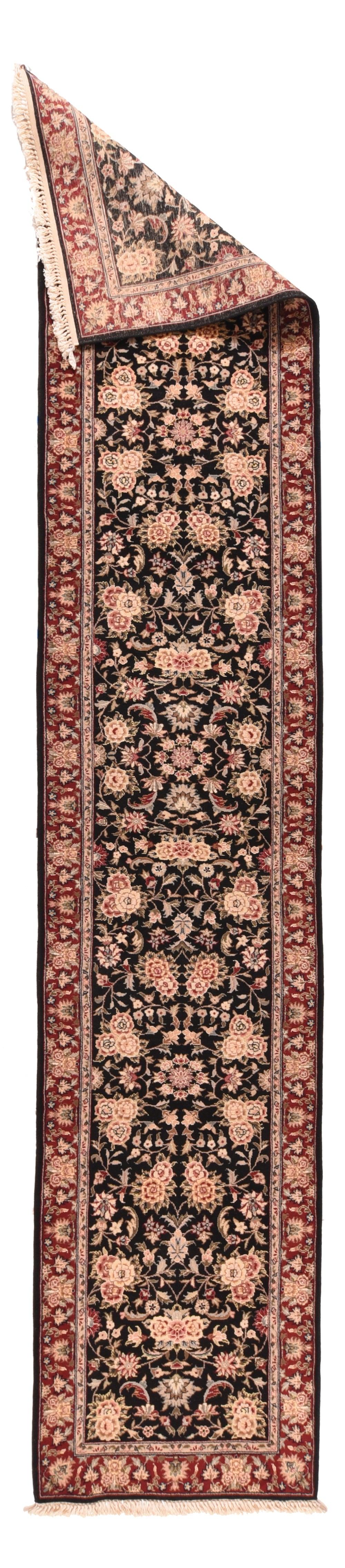 Runner Tabriz 2'3'' x 11'11''. Il campo quasi nero di questo kenare urbano, moderatamente ben tessuto, mostra una rosetta centralizzata e florida che organizza tripli grappoli di rose, rose singole, palmette ruvide e foglie a forma di lancetta, il