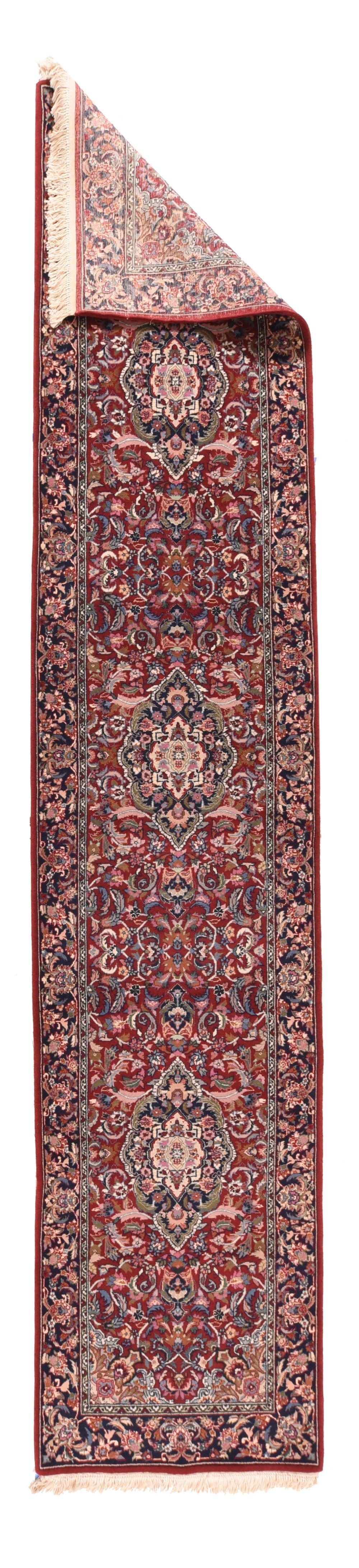 Runner Tabriz 2'6'' x 12'0''. Il campo rosso saturo è fittamente ricoperto da un motivo a tre medaglioni ogivali delicatamente smerlati che sparano foglie verdi a forma di lancetta, con un arabesco ecru di supporto, una falce e una foglia a voluta,