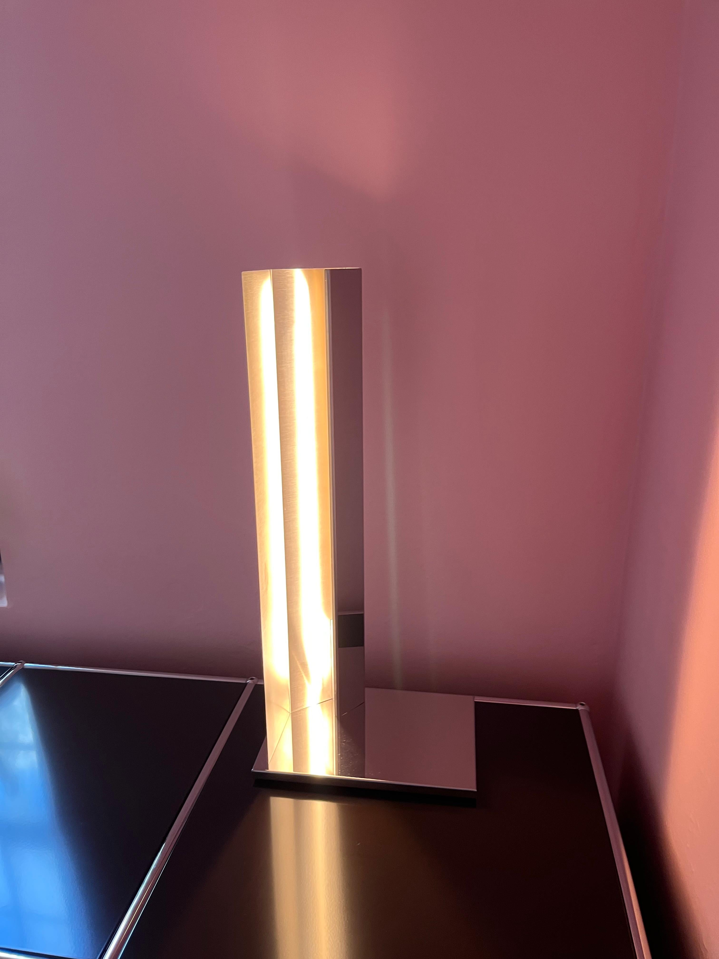 MANO LIGHT - LAMPADA DA TAVOLO -
CM.28X20XH.62
STRUTTURA CROMO LUCIDO (T23)
U.S. WIRED

Un foglio di metallo, pieghe semplici e precise, una luce. Ispirata al gesto della mano che protegge la fiamma di una candela, la collezione Mano Light è