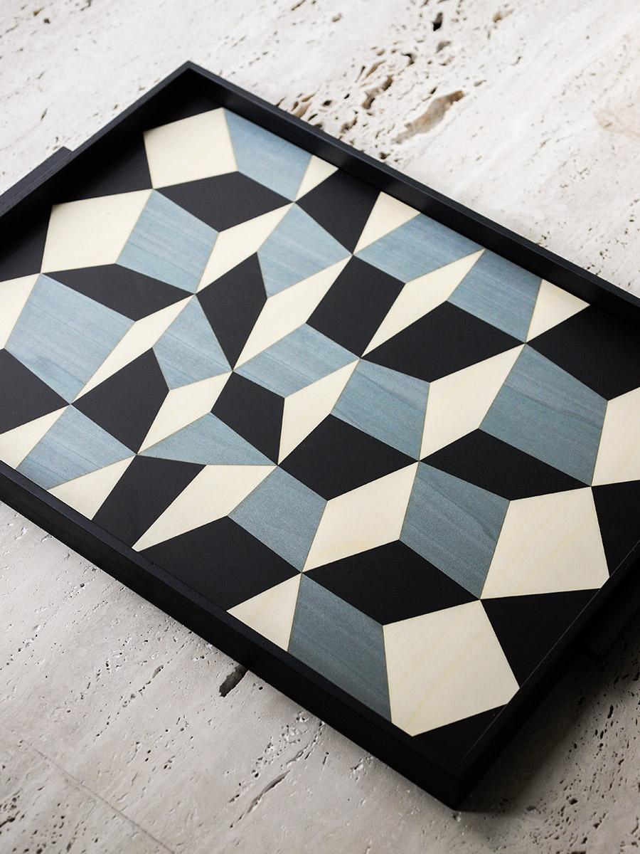 The age-old art of marquetry comes back to life in these two trays, which reinterpret ancient and precious wood- working techniques. Like in a Renaissance workshop, the graphic designs and geometrical patterns of Tarsia trays are created by hand,