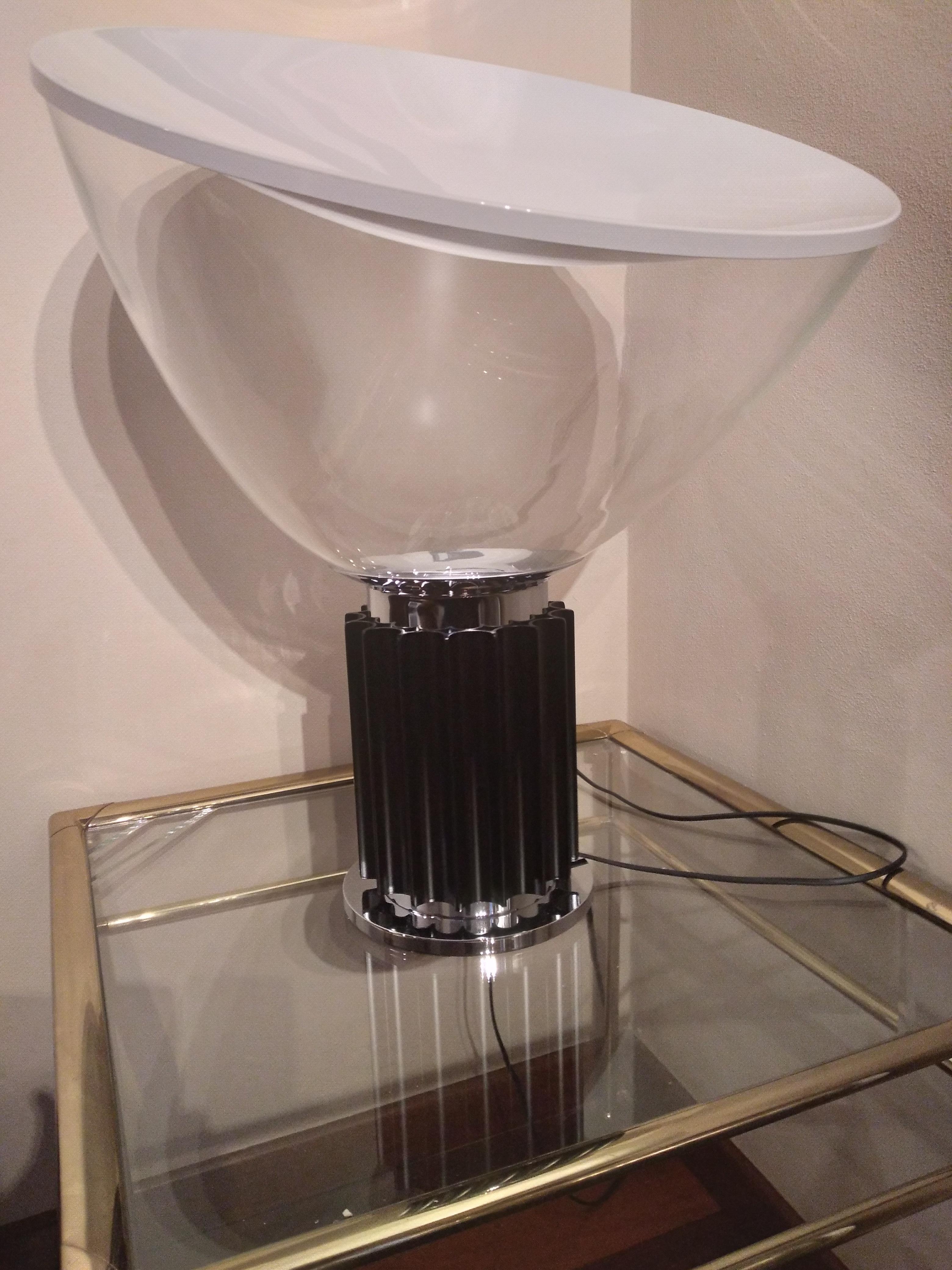 Taccia Lampe von Achille & Pier Giacomo Castiglioni von Flos Hersteller
Die Tisch-/Bodenleuchte Modell Taccia hat einen konkaven Reflektor aus gedrehtem Aluminium mit einer matten Oberfläche. Der Sockel ist aus stranggepresstem Aluminium gefertigt