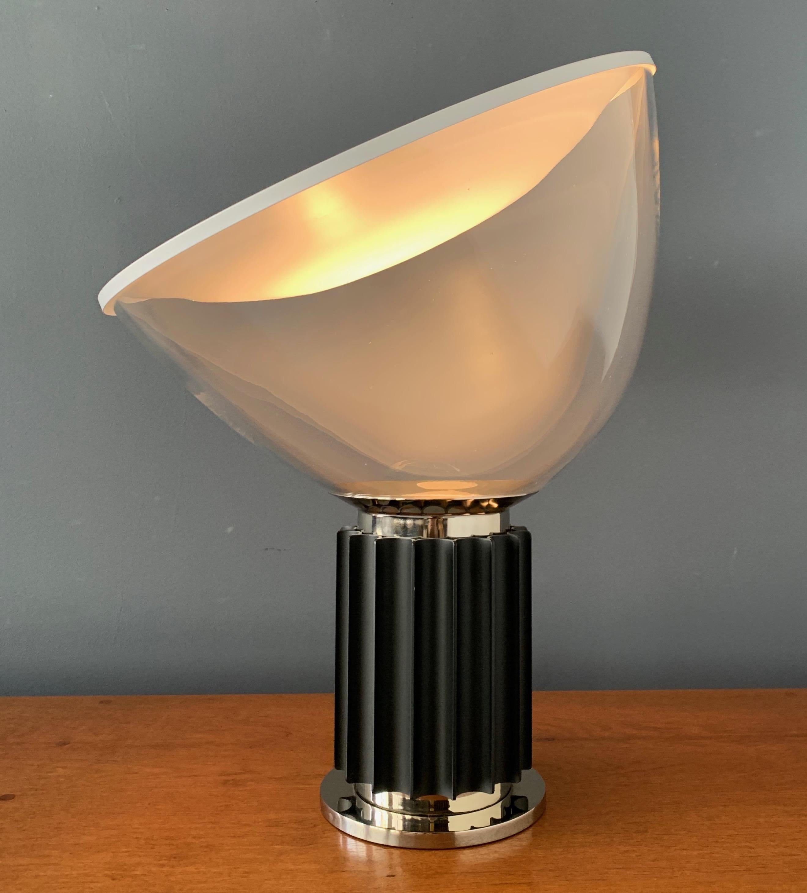 Taccia lamp by Pier Giacomo and Achille Castiglioni for Flos Italy. The lamp is in exceptional original condition. The blown glass shade can pivot upon the metal base fixture to create different lighting effects. From the 1970s-1980s production.
  
