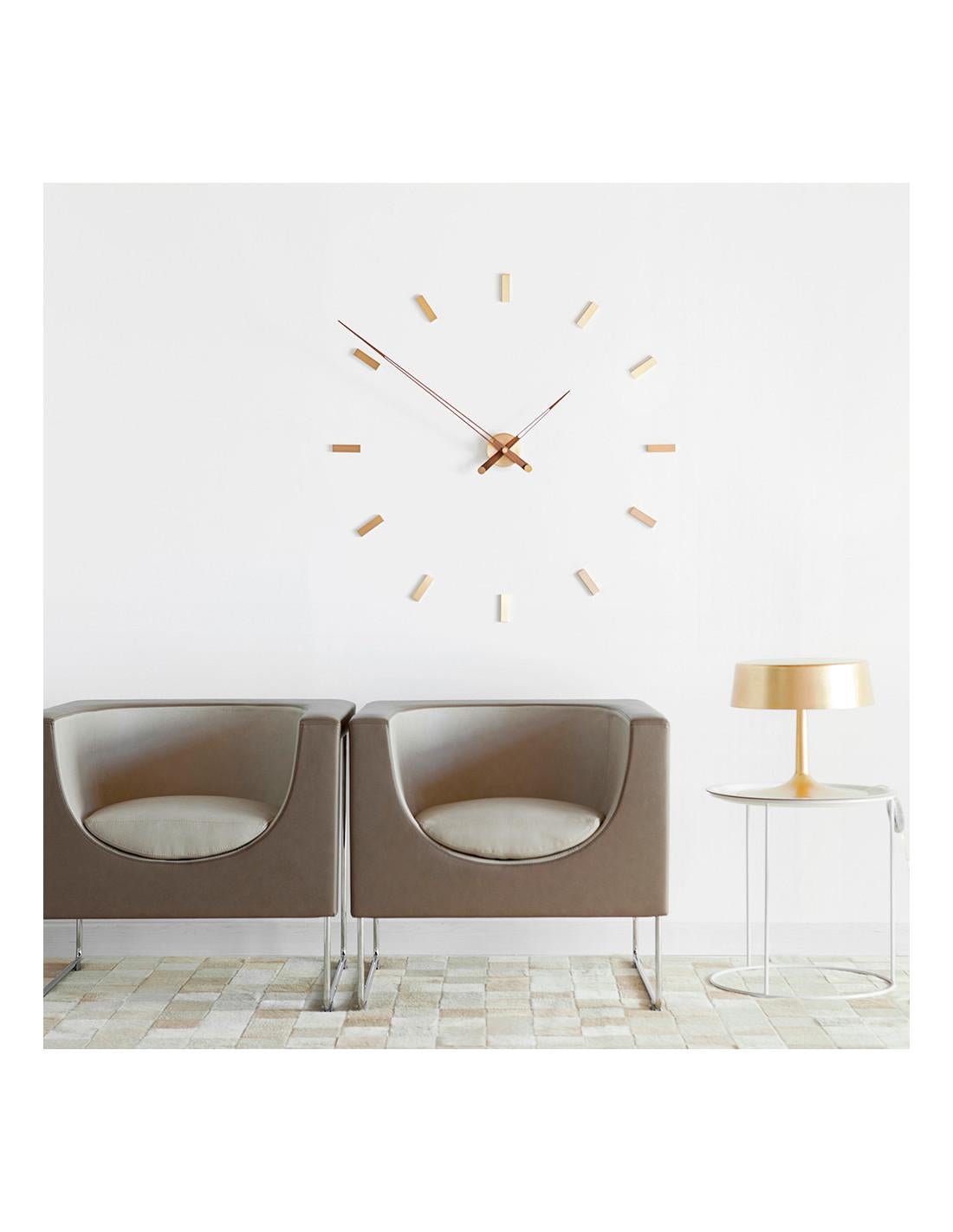 Wall clock with rectangular metal time signals that form the structure of the clock on the wall. The case is polished brass and the hands are walnut with golden counterweights.
Tacón 12 Gold N wall clock: Wood and polished brass.
Each clock is a