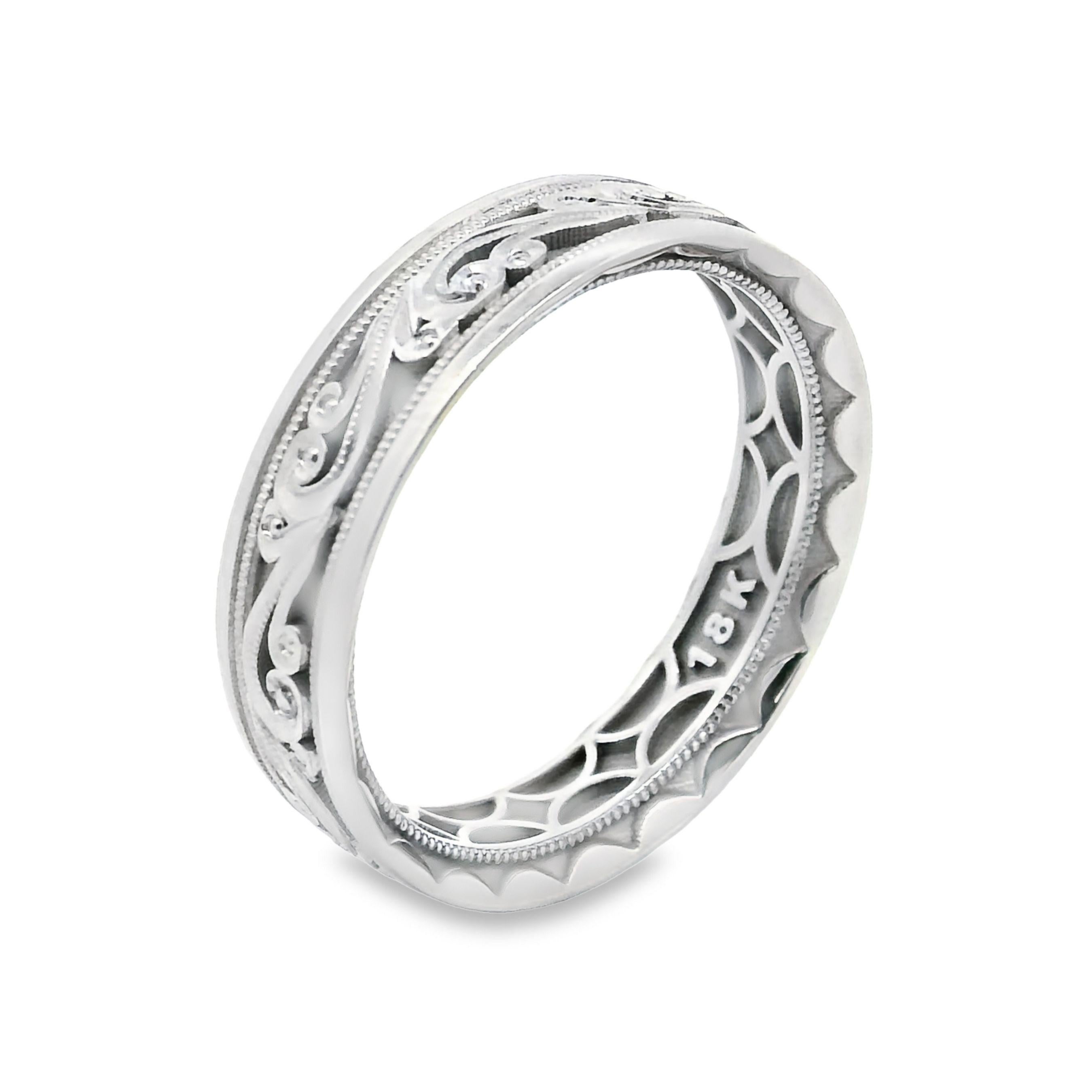 Tacori 104-6W men's wedding band in 18K white gold and 6 millimeters in width.  This ring has a brushed finish, overlayed with filigrees along the center of the ring, bordered by a beaded design.  At the outer most edge is a high polish finish,