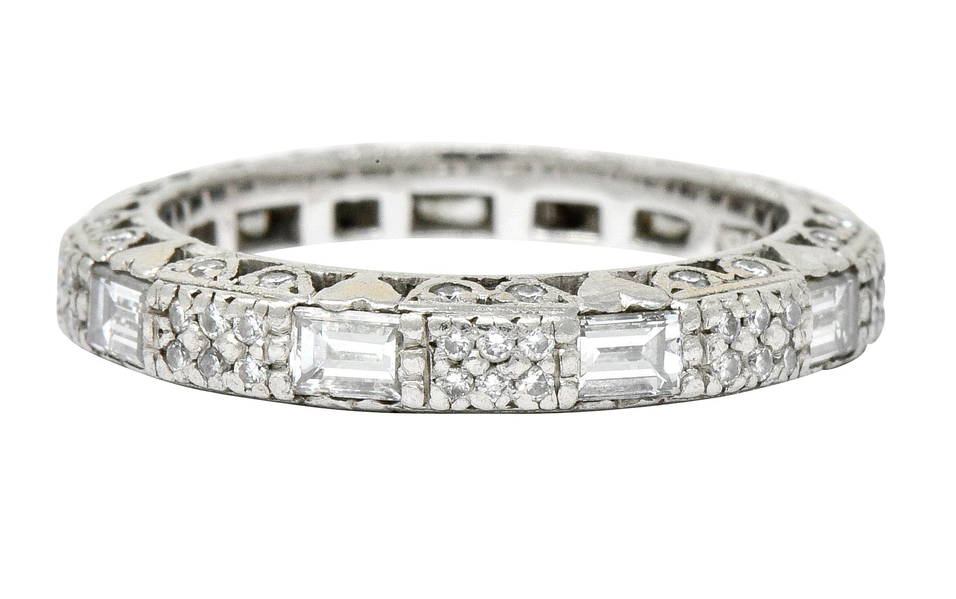 Eternity style band designed as segments of pavè diamonds alternating with flush set baguette cut diamonds

With a profile comprised of a pierced heart motif accented by bead set round brilliant cut diamonds

Total diamond weight is approximately
