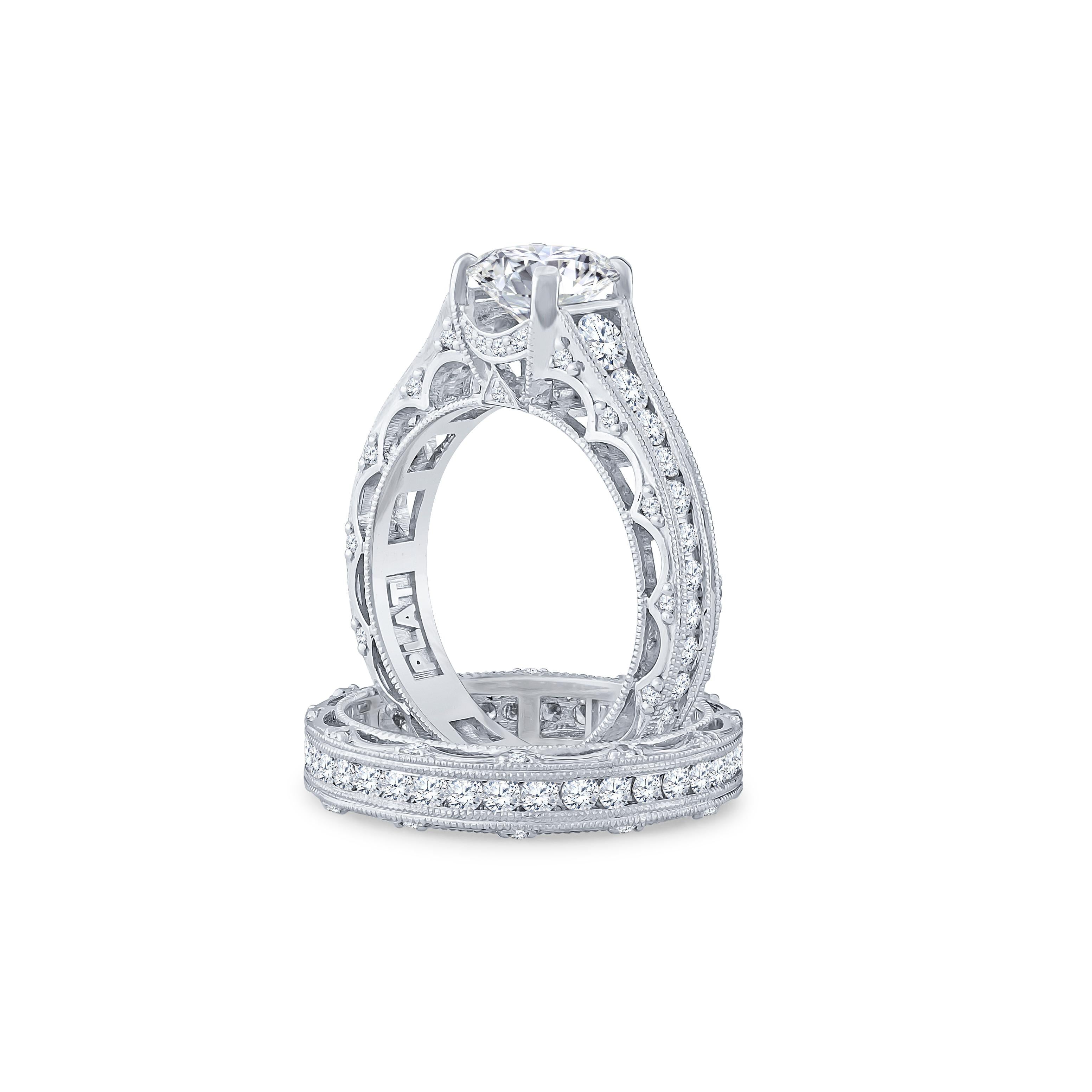 This stunning platinum engagement ring centers a sparkling GIA certified round brilliant cut diamond that weighs 1.53 carat graded J color with VS2 clarity. The center diamond and the wedding band are accentuated by dazzling round cut diamonds that