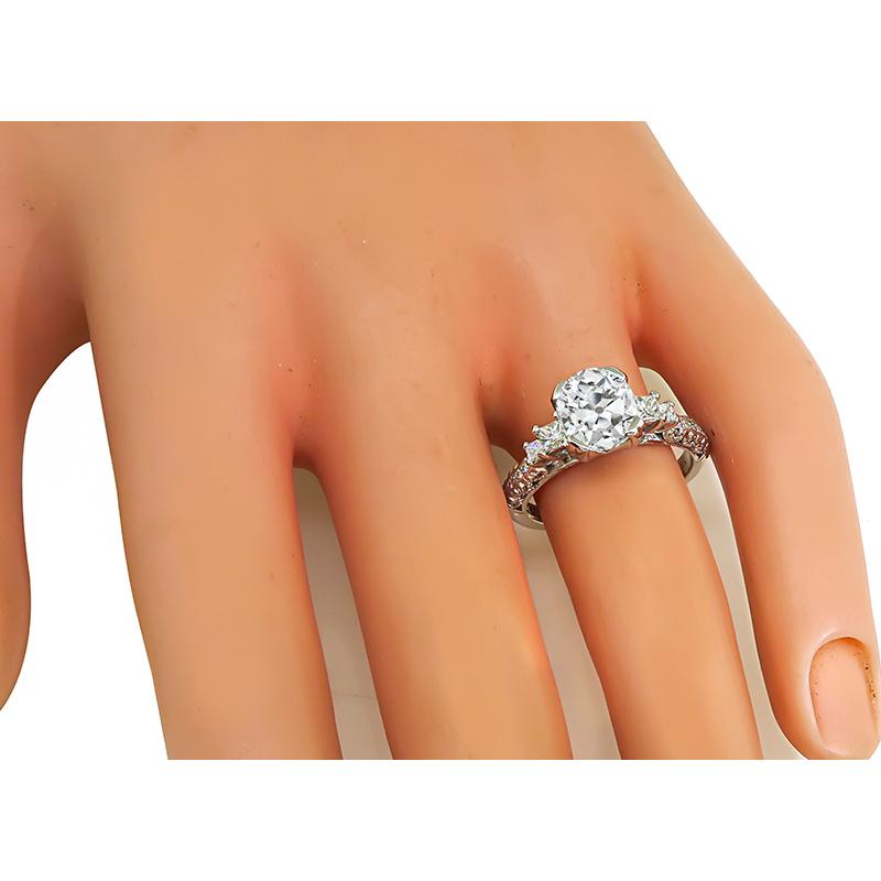 This is a stunning 18k white gold engagement ring by Tacori. The ring is centered with a sparkling cushion cut diamond that weighs approximately 2.00ct. The color of the diamond is I with I1 clarity. The center diamond is accentuated by dazzling