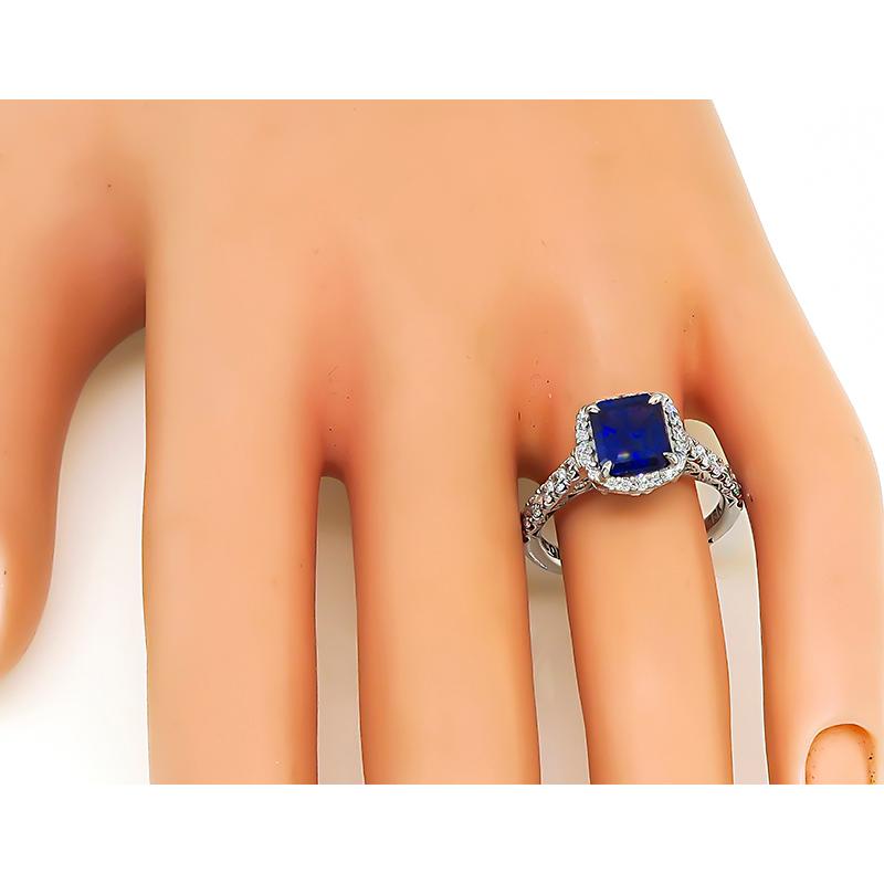 This is an amazing 18k white gold engagement ring by Tacori. The ring is centered with a lovely emerald cut Ceylon sapphire that weighs approximately 2.02ct. The center stone is accentuated by sparkling round cut diamonds that weigh approximately