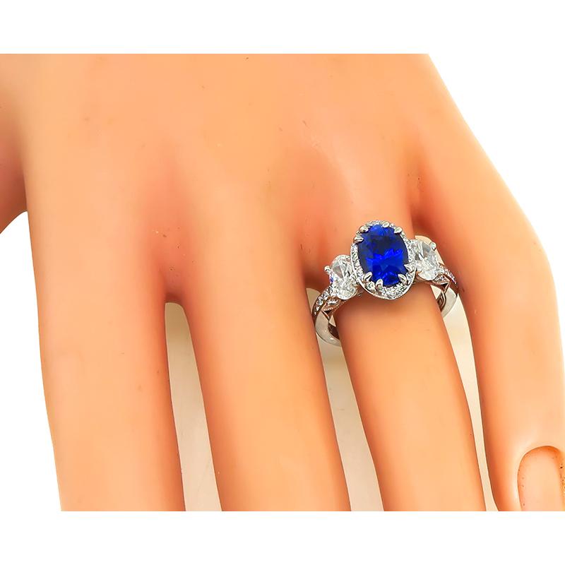 This is an amazing platinum engagement ring by Tacori. The ring is centered with a lovely oval cut Ceylon sapphire that weighs approximately 2.14ct. The sapphire is accentuated by two sparkling oval cut diamonds that weigh approximately 1.00ct. The