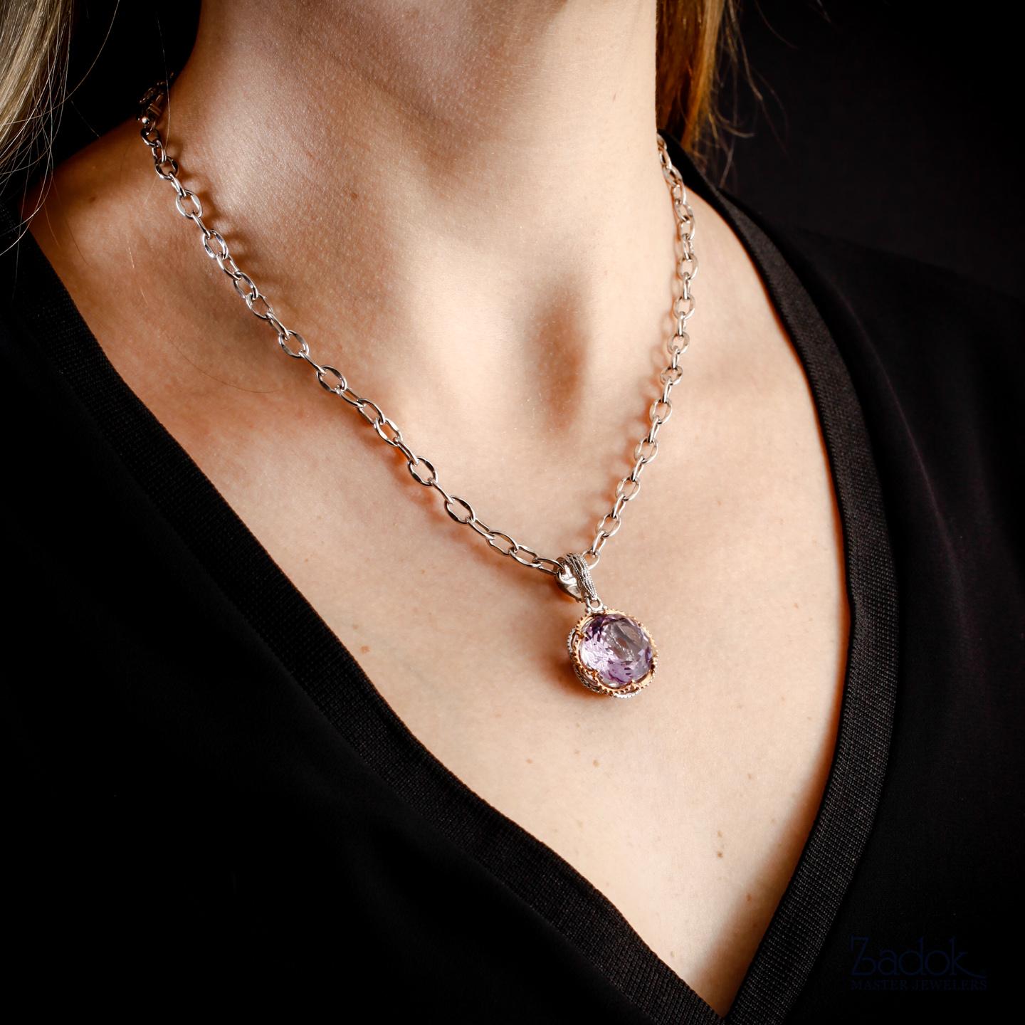 This Tacori pendant contains and amethyst set in sterling silver and 18k rose gold on an 18 inch sterling silver chain. This necklace is in excellent condition and has never been worn. 