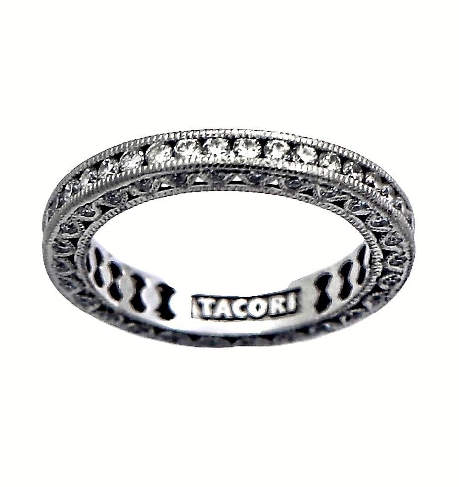 This engaging 18K white gold eternity band by Tacori is a modern classic.
It is fashioned to look like a vintage band, but with a more modern flair.
Fine quality, round brilliant cut diamonds are set down the center and on both sides of the band.