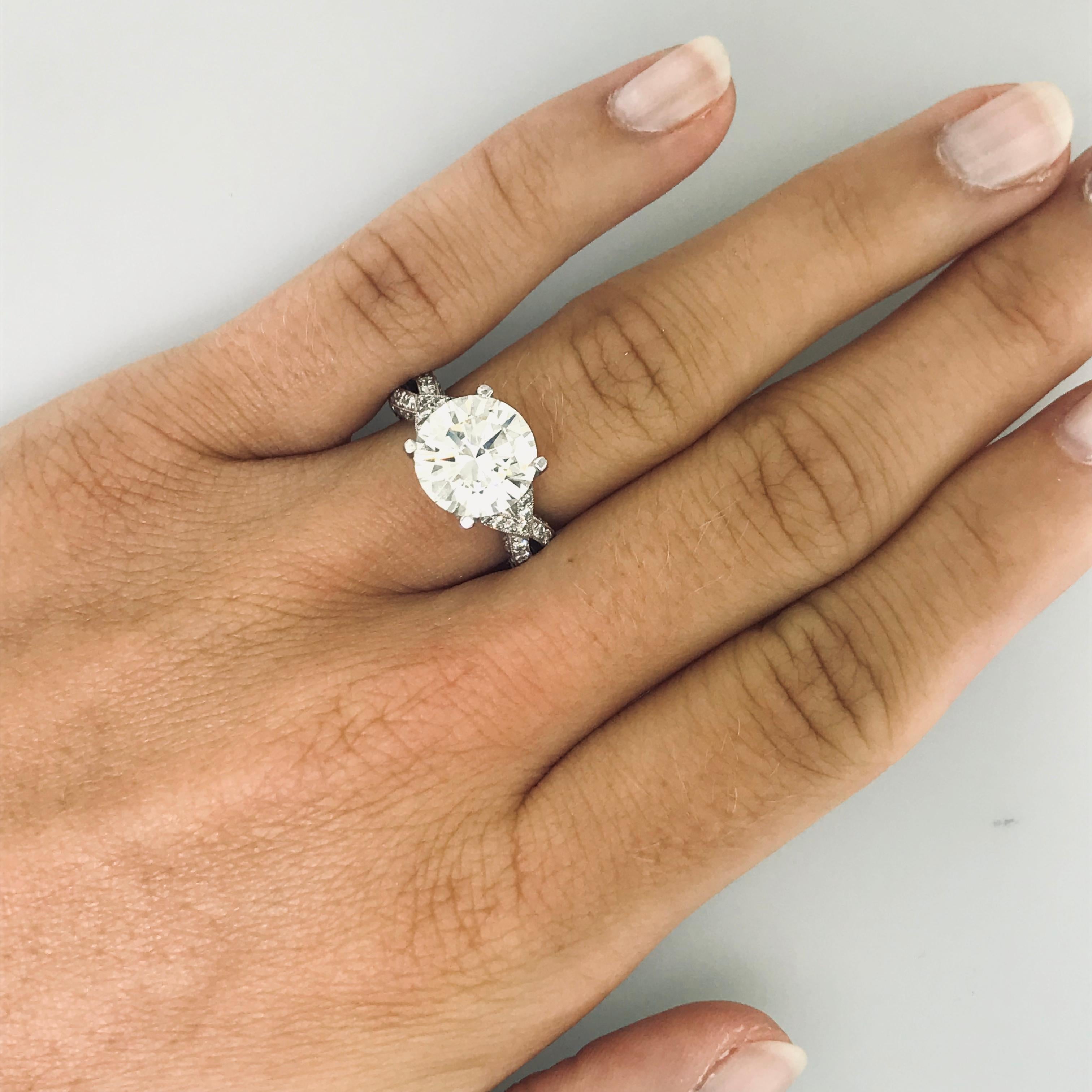 This iconic platinum diamond ring is a Tacori Royal T stunner!  The 4.00 carat round diamond is GIA-certified. The Tacori Royal T designed ring has an open criss-cross woven infinity design on the shoulders and small accent diamonds are pave-set