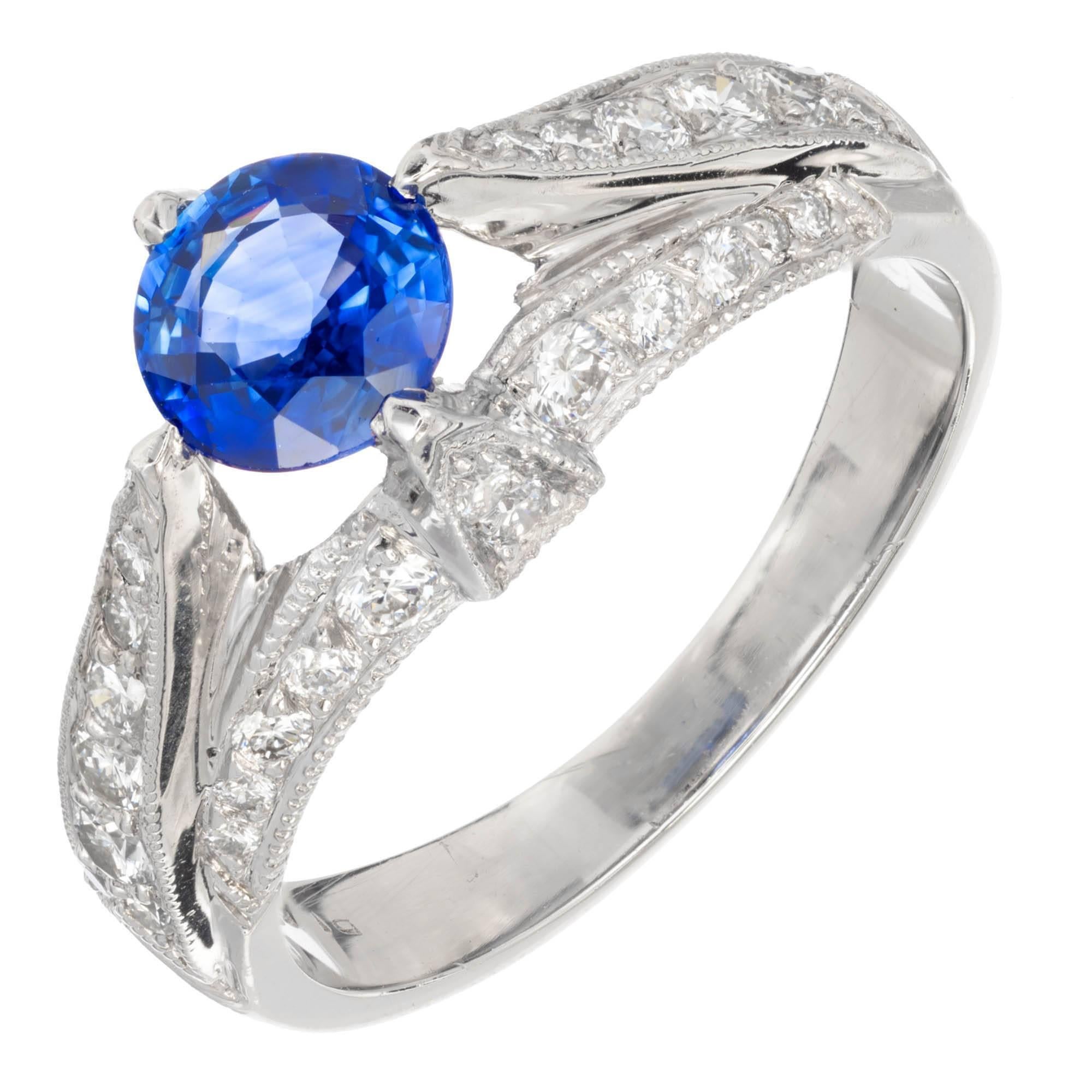 Tacori platinum sapphire and diamond Tacori engagement ring. The Center sapphire is accented on each size with round brilliant cut diamonds graduating from small to large with diamonds also set across shank of ring.

1 round blue sapphire