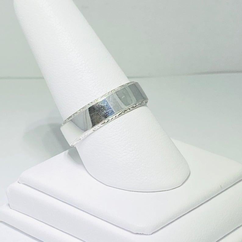 This authentic Tacori Man’s Wedding Band is brand new and a size 10. This band is gorgeous and has amazing intricate designs all around the sides! It is part of our Tacori closeout sale! It is an 18 karat white gold band with a flat band and