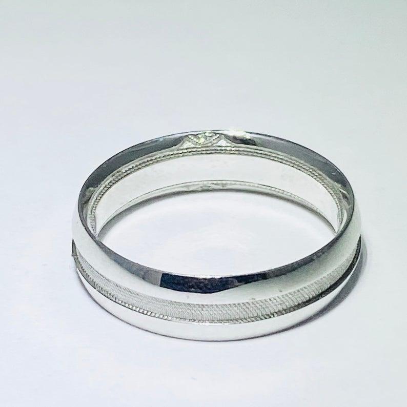 This genuine and authentic Tacori man’s wedding band has a super unique design and is part of our Tacori closeout sale! It is an 18 karat white gold band with intricate mesh-like detail across the center of the band. Two hidden diamonds accent the