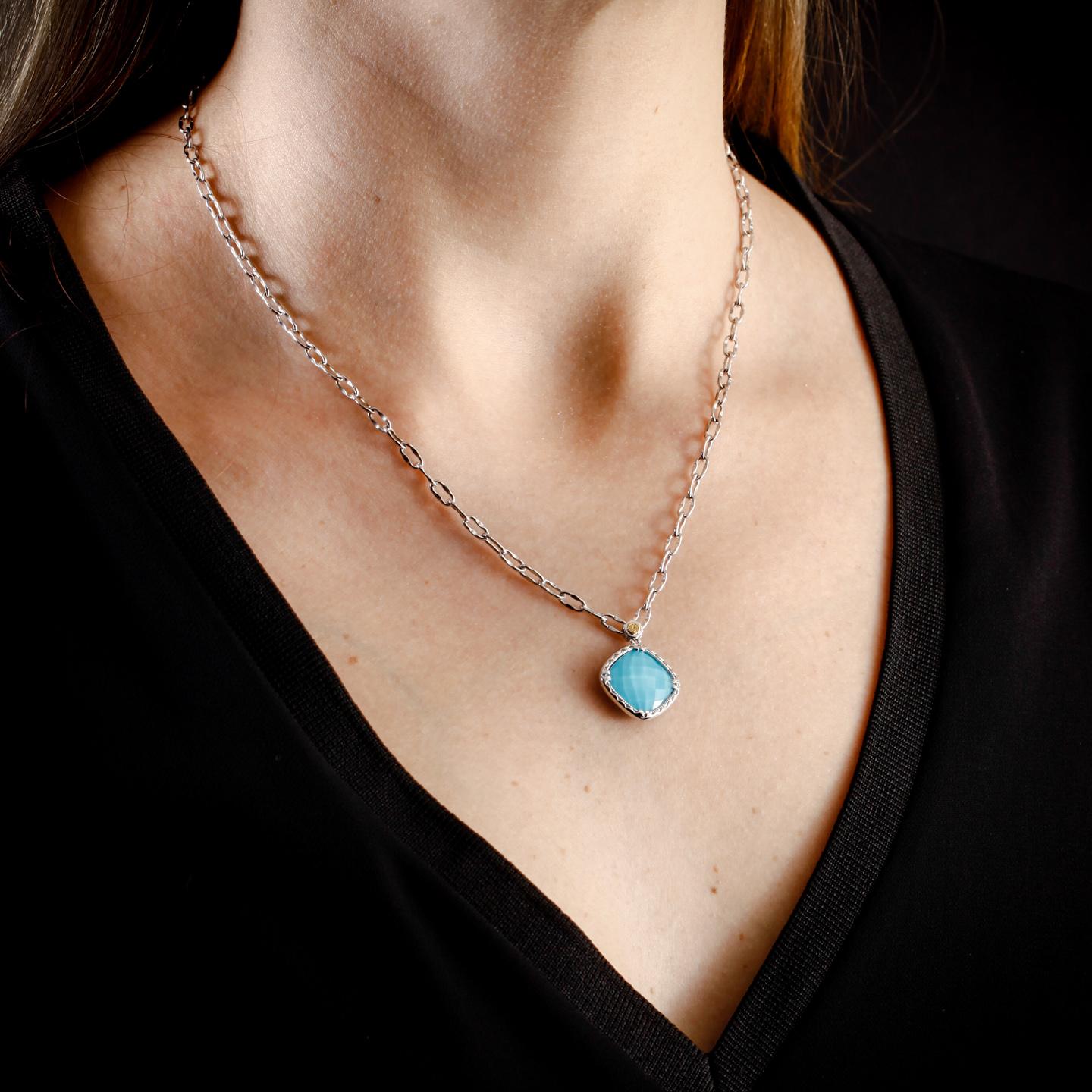 This Tacori Silver necklace is set with a 7.00 ct. cushion-shaped pendant of turquoise and clear quartz surrounded by silver. The Tacori stamp featured on the bale is 18k yellow gold. The silver Tacori chain is 18 inches long. This necklace is in