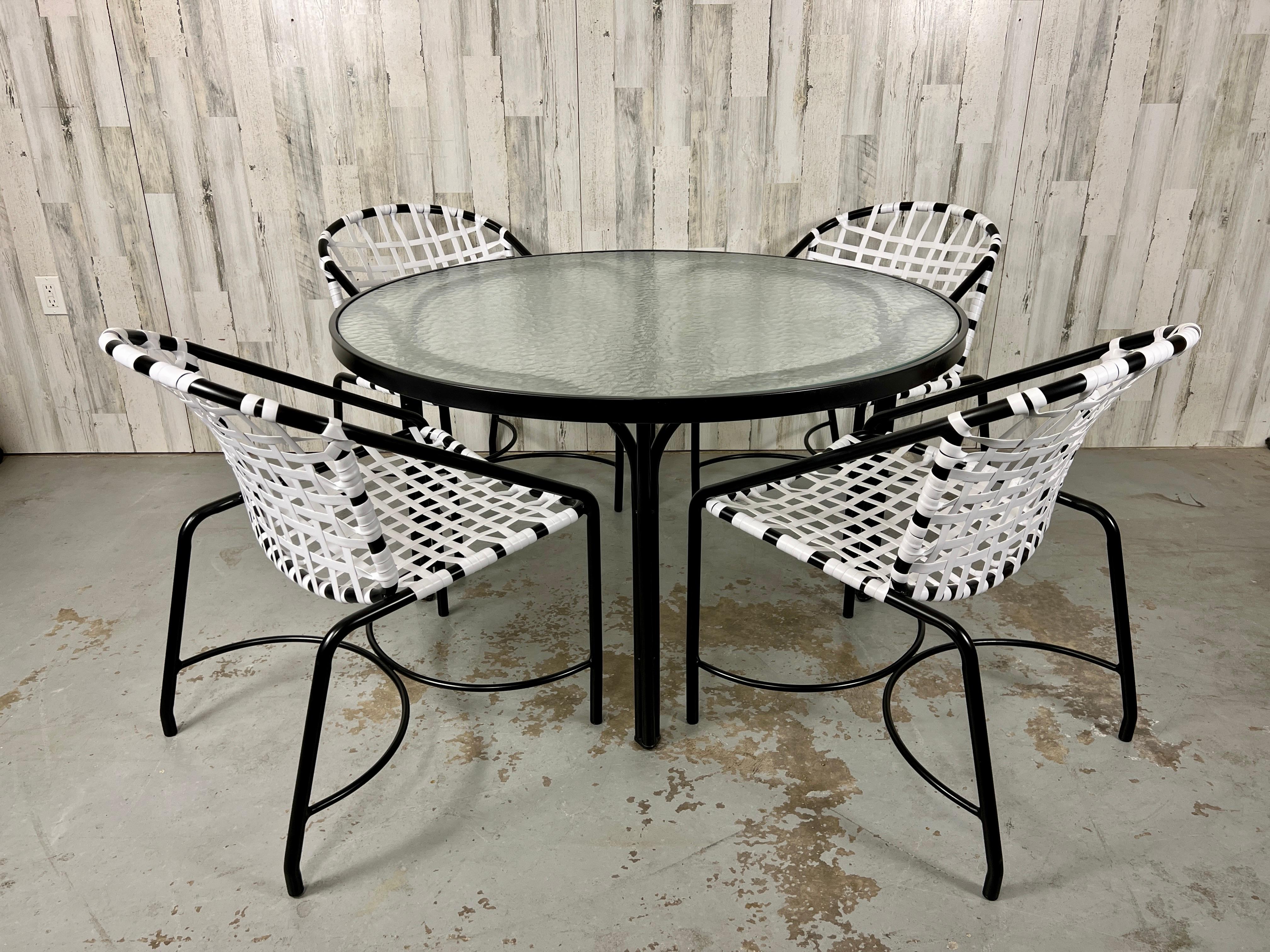 Vintage By vier Esstischstühle von Tadao Inouye für Brown Jordan Kantan mit rundem Esstisch Vollständig restauriert mit neuer schwarzer Pulverbeschichtung des Gestells und kontrastierenden weißen Gurten. Das Glas auf dem Tisch ist originales