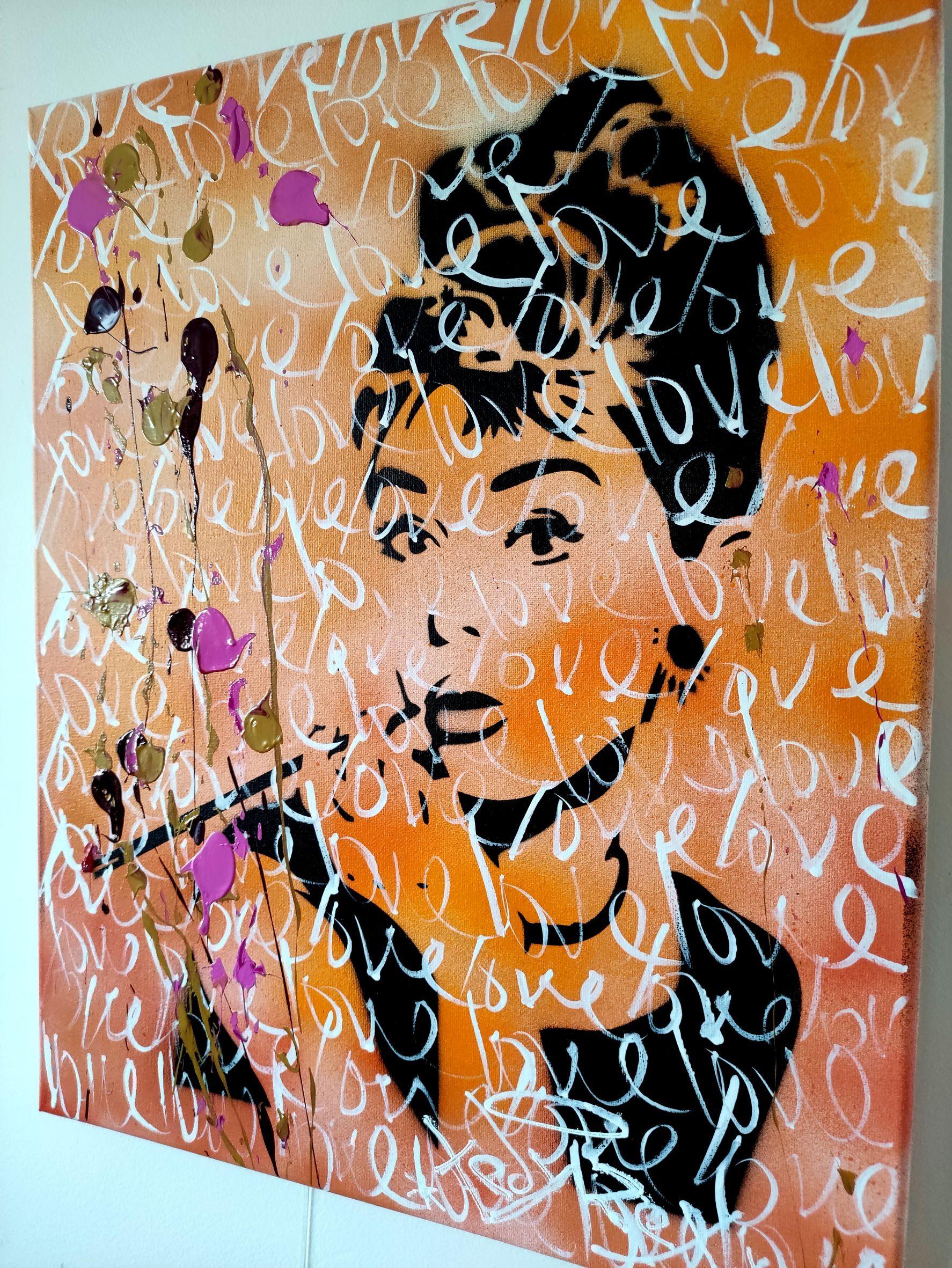 Questo quadro è un omaggio all'iconica attrice Audrey Hepburn. Presenta uno stencil nero del suo volto su uno sfondo arancione, con la parola 