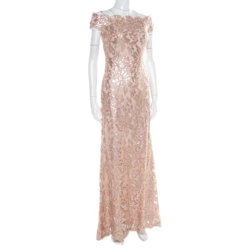 Pick this evening gown from Tadashi Shoji when you want to be an attention grabber at the party. Designed for luxury, this lovely blush pink gown has an off-shoulder design with floral patterns accented with sequins all over. The outfit falls to an