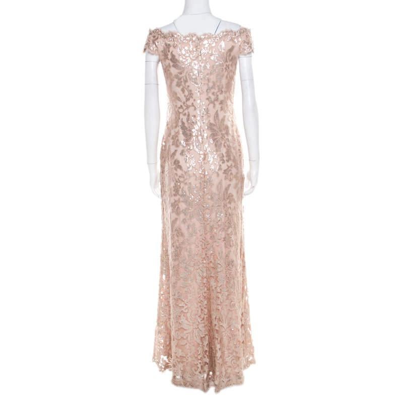 Pick this evening gown from Tadashi Shoji when you want to be an attention grabber at the party. Designed for luxury, this lovely blush pink gown has an off-shoulder design with floral patterns accented with sequins all over. The outfit falls to an