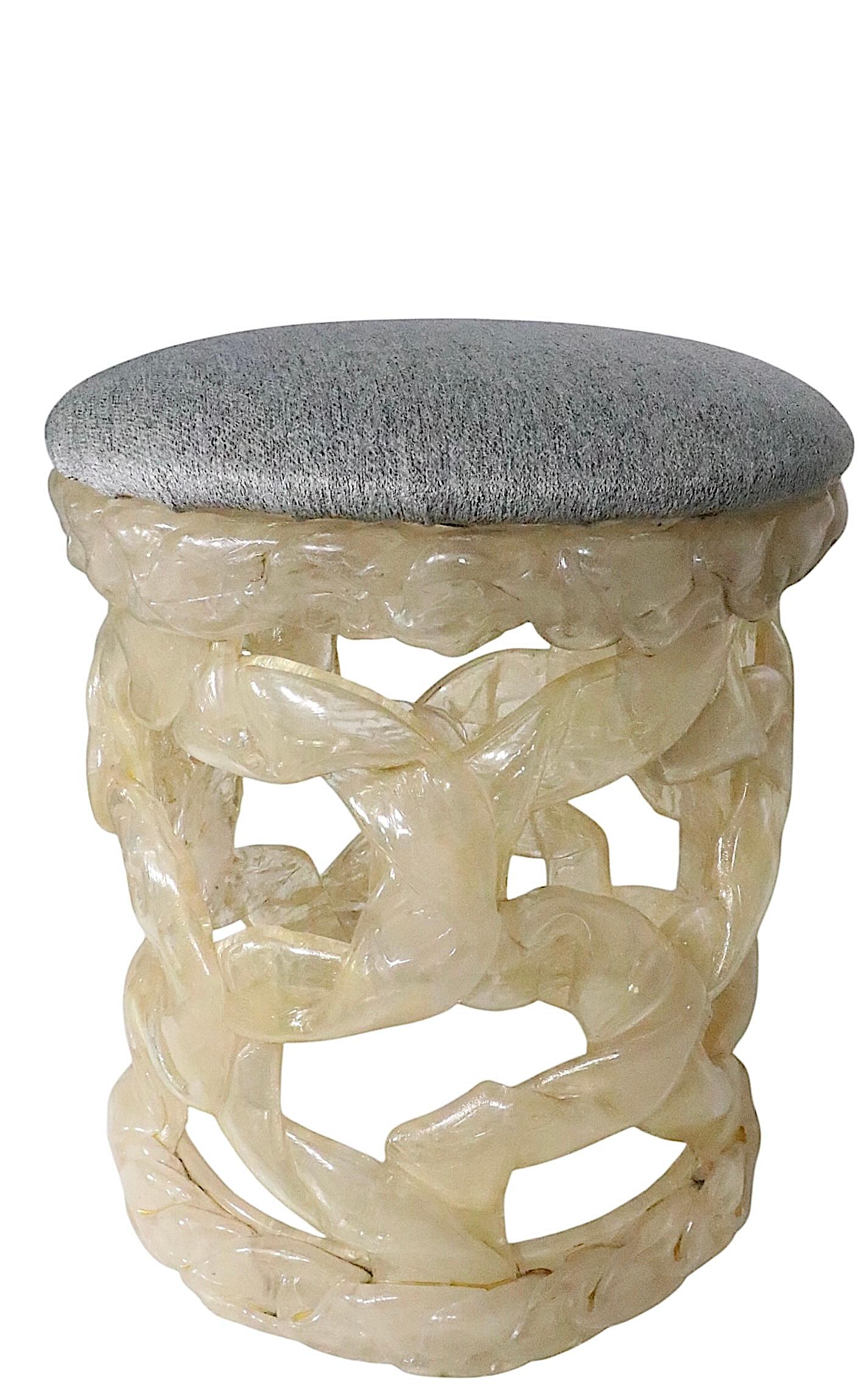 Voguish, chic and stylish ribbon style resin stool with an upholstered pad seat. The resin is a translucent opalescent off white tone, the fabric top is a bluish gray color. This example is in very good, clean and ready to use condition, showing