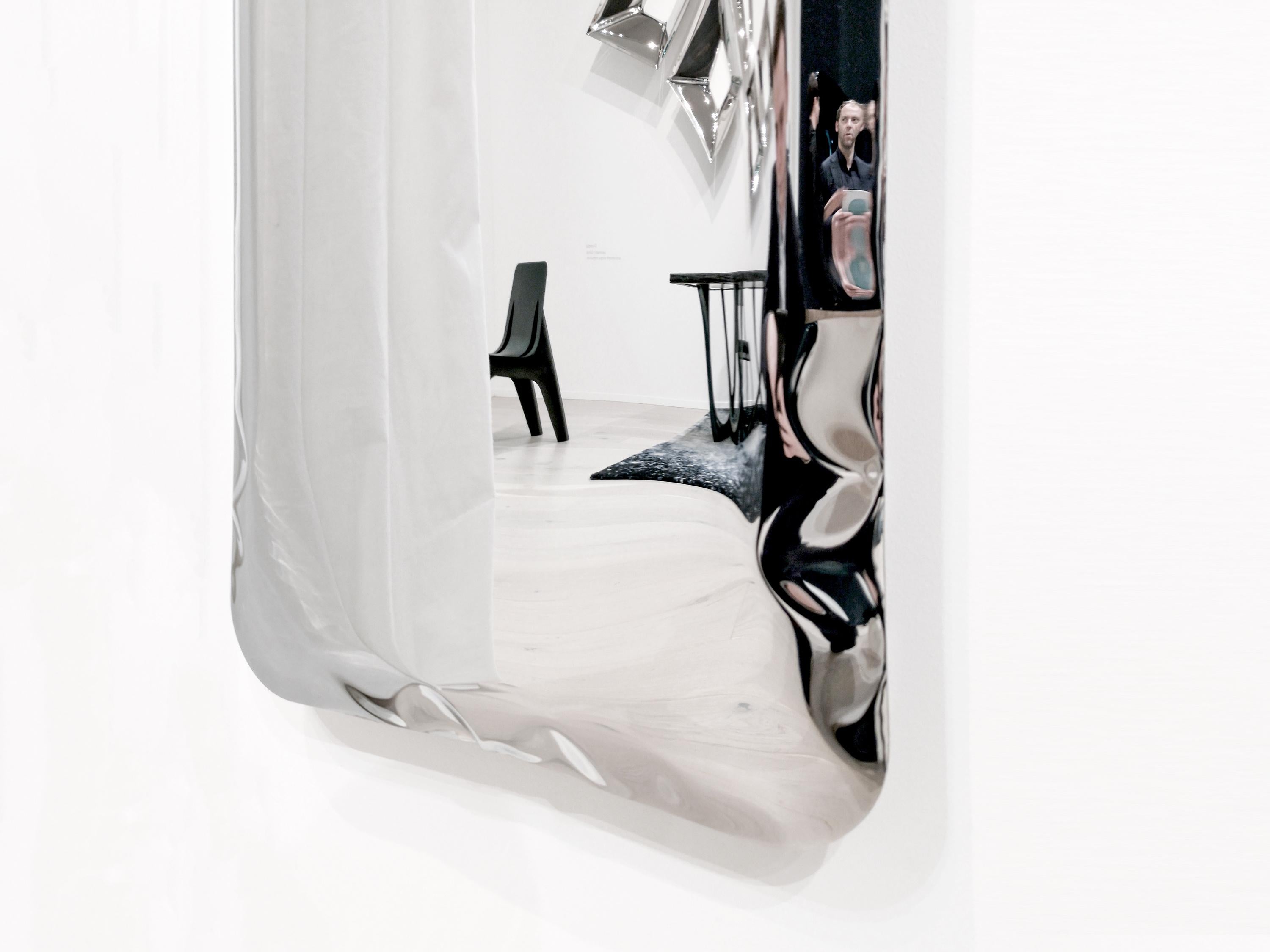 Elongated mirror, made of polished stainless steel.