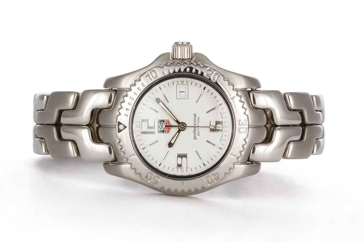 We are pleased to offer this Ladies Tag Heuer Stainless Steel Professional WT1314. It features a 31mm stainless steel case, polished and satin finish links on the bracelet, white dial and quartz movement. It will fit up to a 6.75