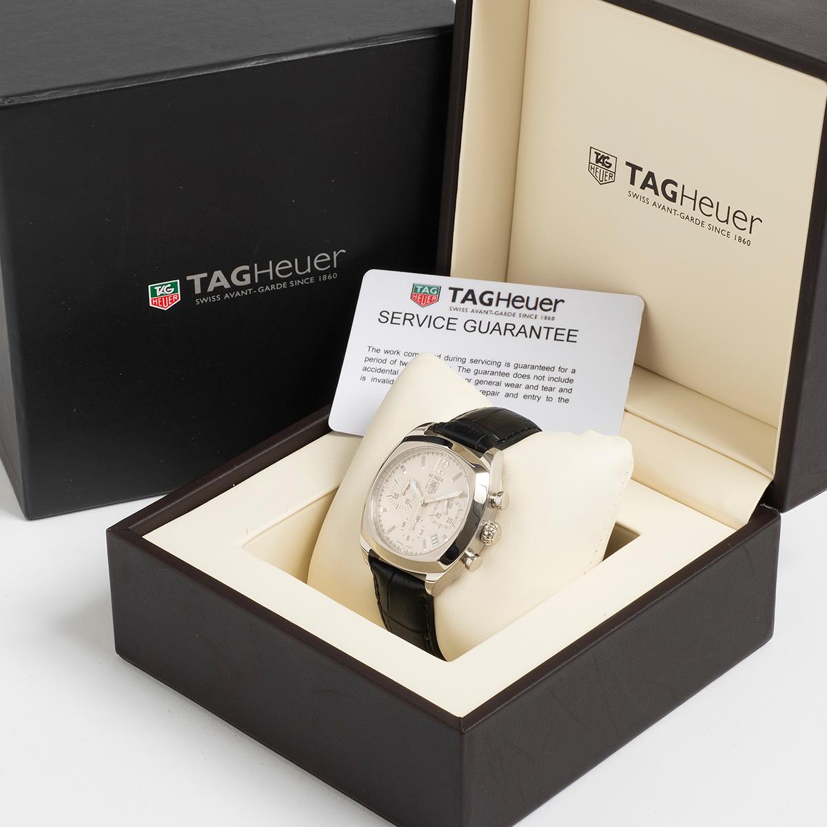 Unsere Tag Heuer Monza Referenz CR2114-0 mit Chronograph und Datum verfügt über ein 38-mm-Edelstahlgehäuse mit einem attraktiven weißen Zifferblatt. Die Uhr ist an einem schwarzen Tag Heuer Service-Lederband mit Faltschließe befestigt und befindet