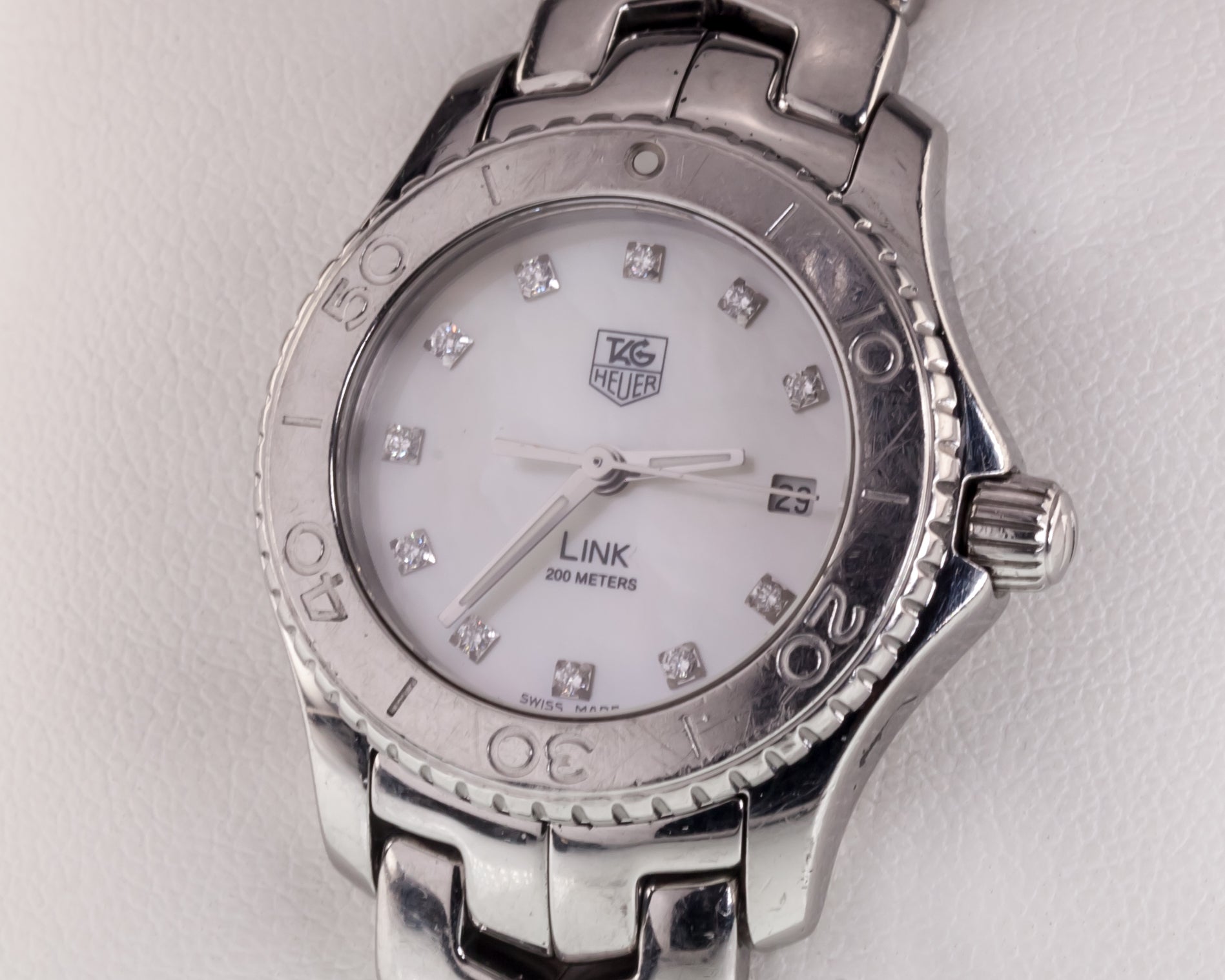 Tag Heuer Stainless Steel Women's Quartz Link Watch w/ MOP Diamond Dial WJ1319
Movement #f03111
Case #WJ1319_O_XE5925

Stainless Steel Round Case w/ Rotating Diver's Bezel
NOTE: Some scratches on bezel
25 mm in Diameter (29 mm w/ Crown)
Lug-to-Lug