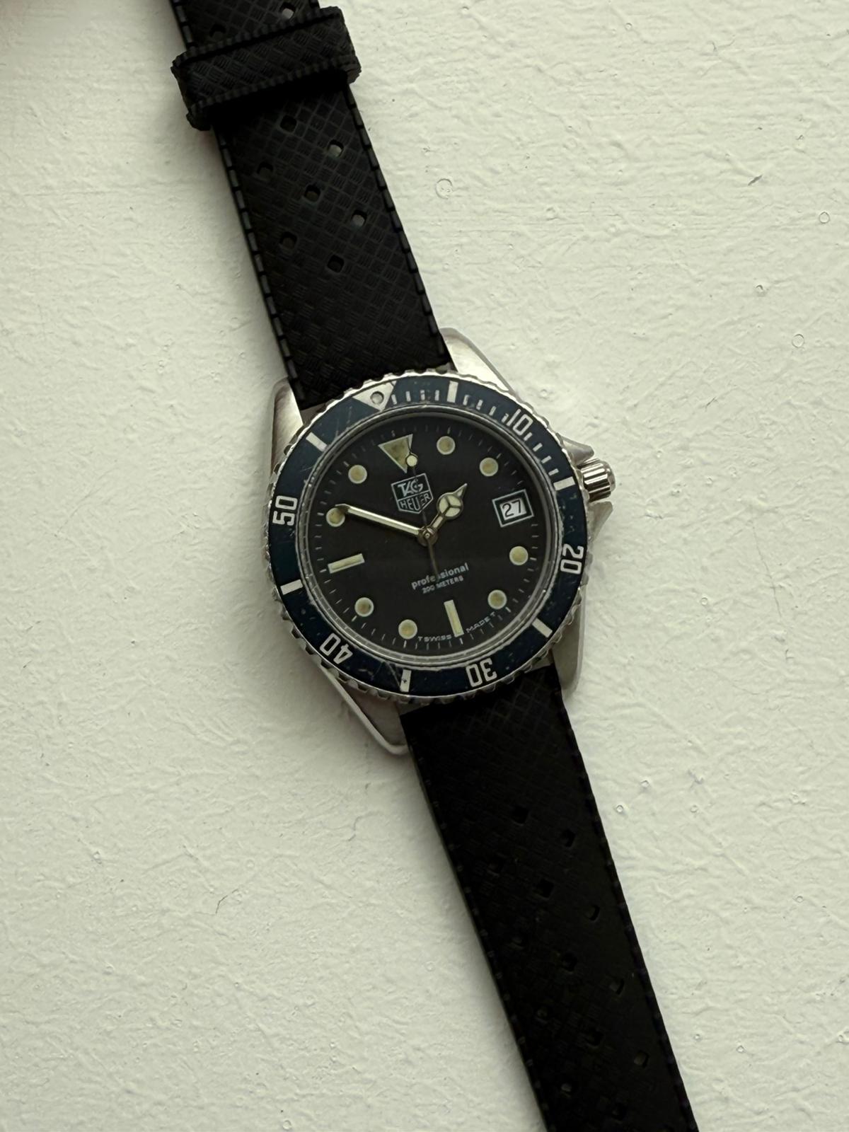 Notre Tag Heuer vintage est une référence de transition 980.013B/ série 1000 et présente un boîtier en acier inoxydable de 38 mm. Le cadran et la lunette noirs sont très patinés, la lunette a une teinte bleutée. Il y a des signes d'utilisation dans