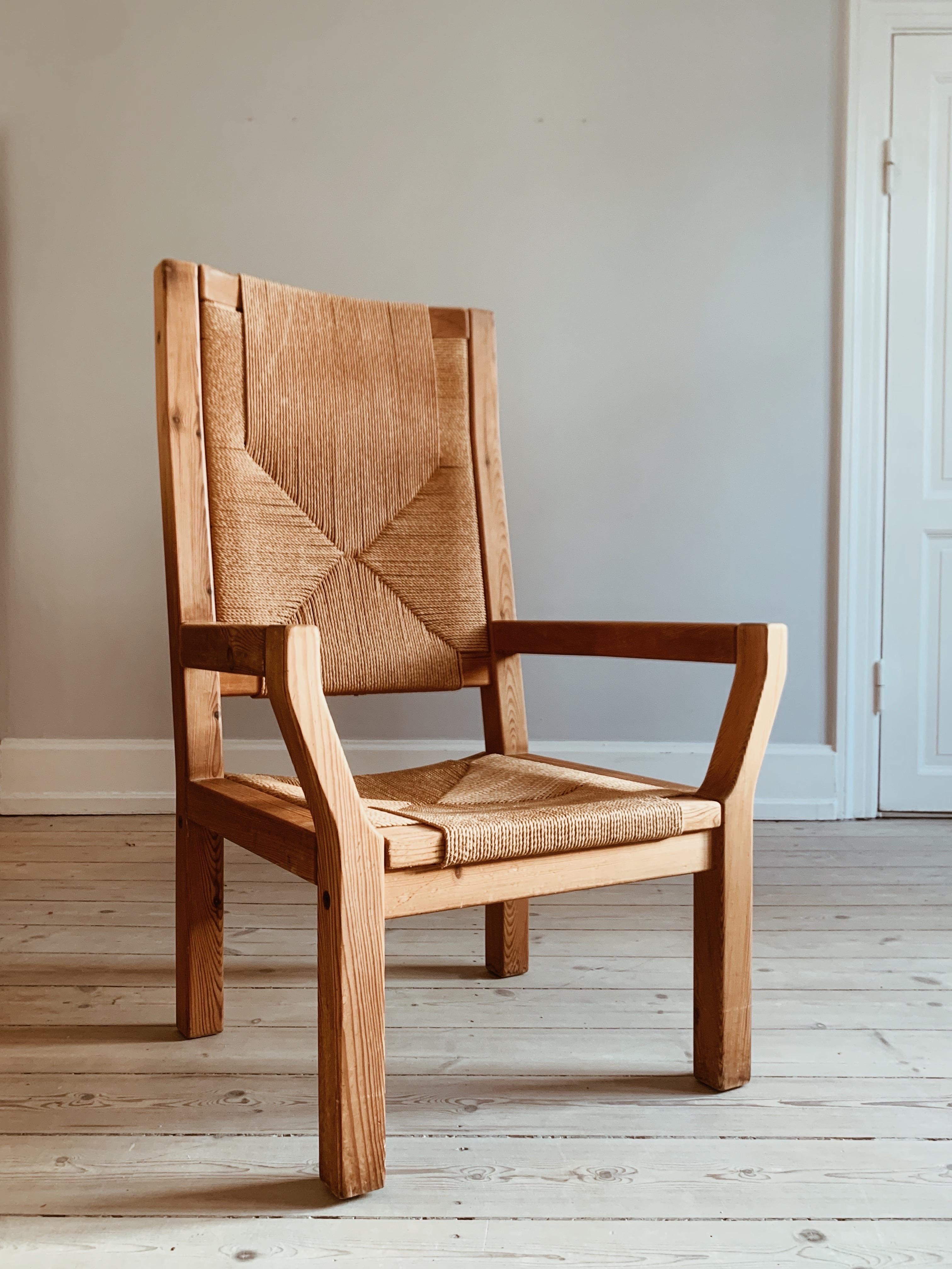 Fauteuil à dossier haut et brutal de l'architecte danois Tage Poulsen.

La chaise est en pin patiné et son assise et son dossier à haut dossier sont en osier. 

Des années 1960, lorsque les chaises étaient robustes et brutales - avec une expression