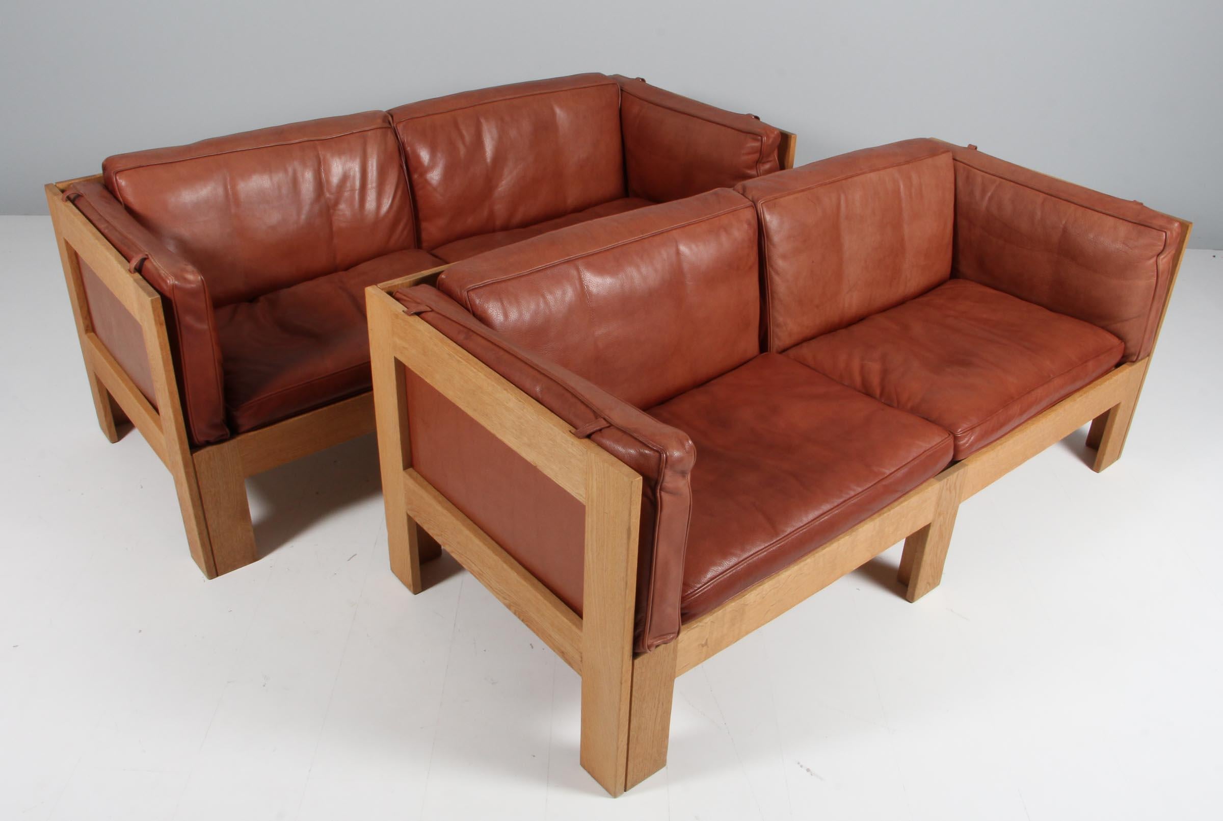 Tage Poulsen two seater sofa in oak and patinated aniline leather.

Nylon webbing as straps.