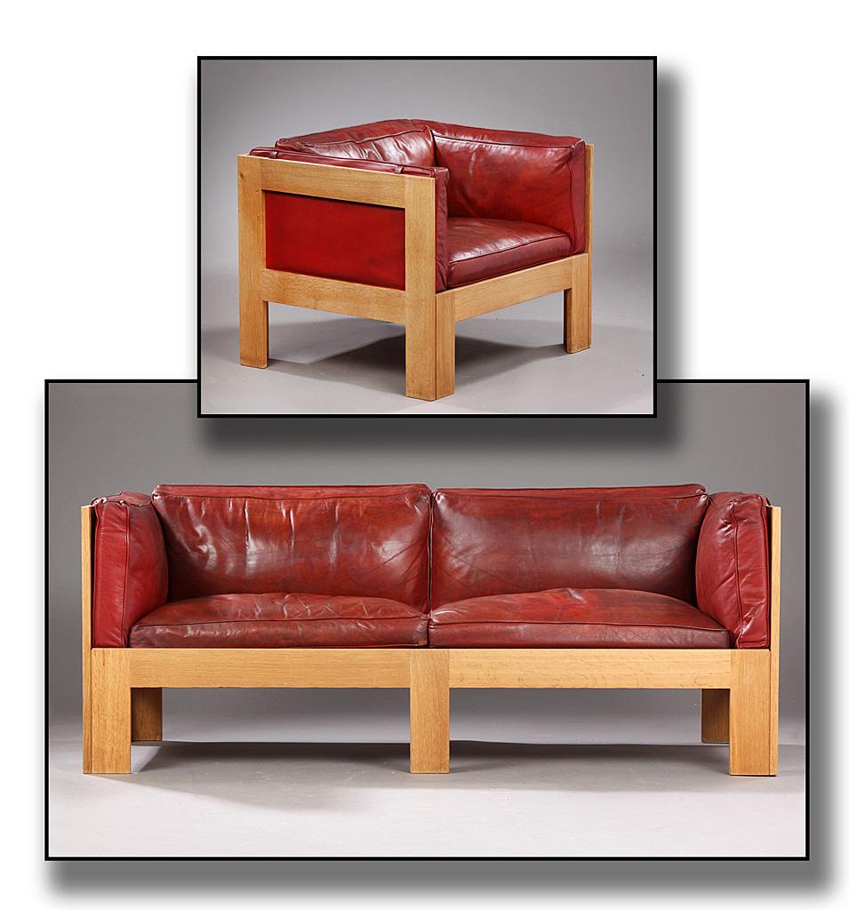 Danish architect and Professor Tage Poulsen. Freestanding two-seat sofa and armchair, loose cushions upholstered in red/brown patinated leather, frame with oakwood lining, bottom with nylon lace. Sofa L. 160 cm D. 70 cm H. 64 cm. Armchair B. 80 cm.
