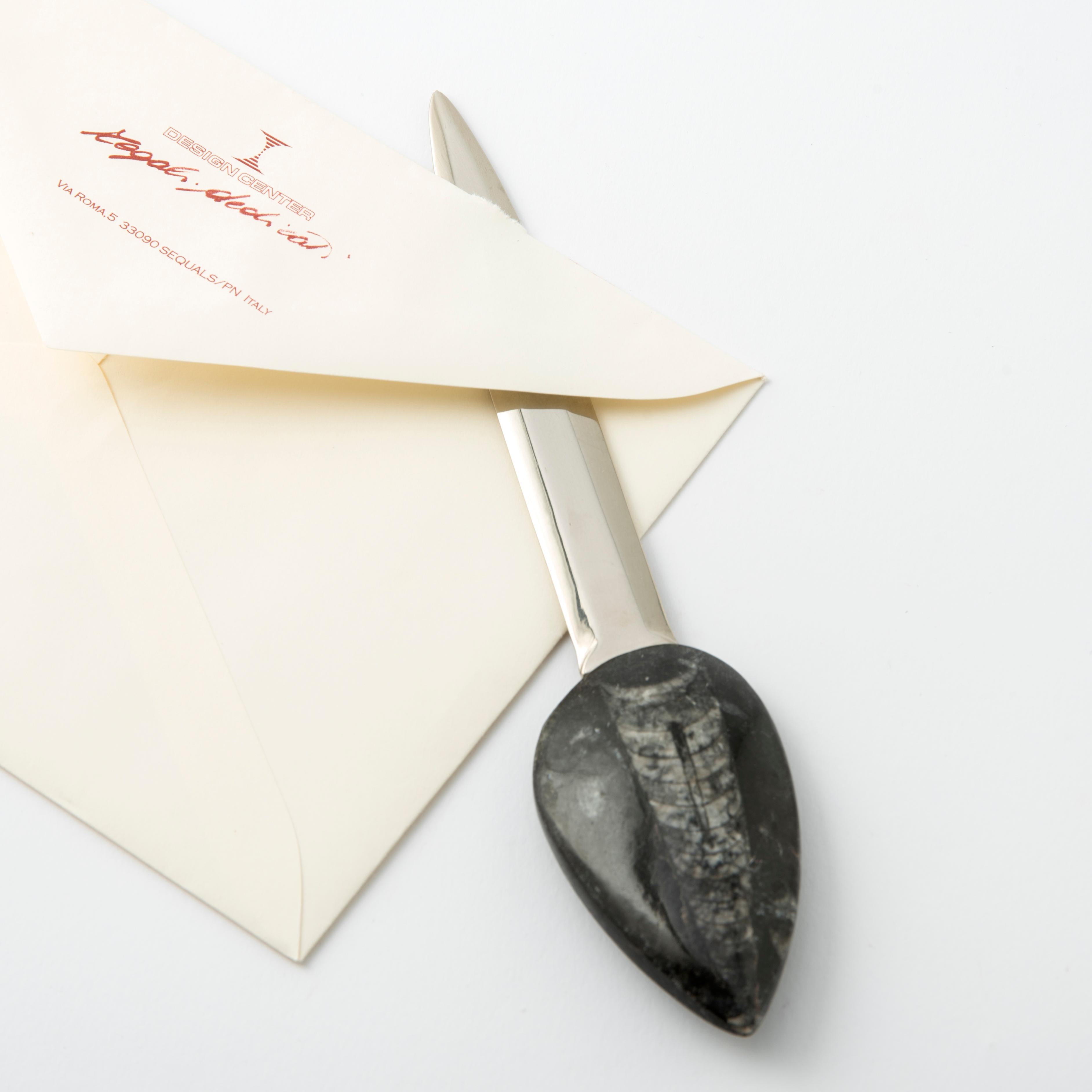 Ein eleganter Brieföffner mit einem Griff aus einem authentischen Fossil von Orthoceras - einem über 360 Millionen Jahre alten Nautiloid aus der Sahara. 
Die konische, leicht gewölbte Schale, die auf einem felsigen Untergrund ruht, verwandelt sich